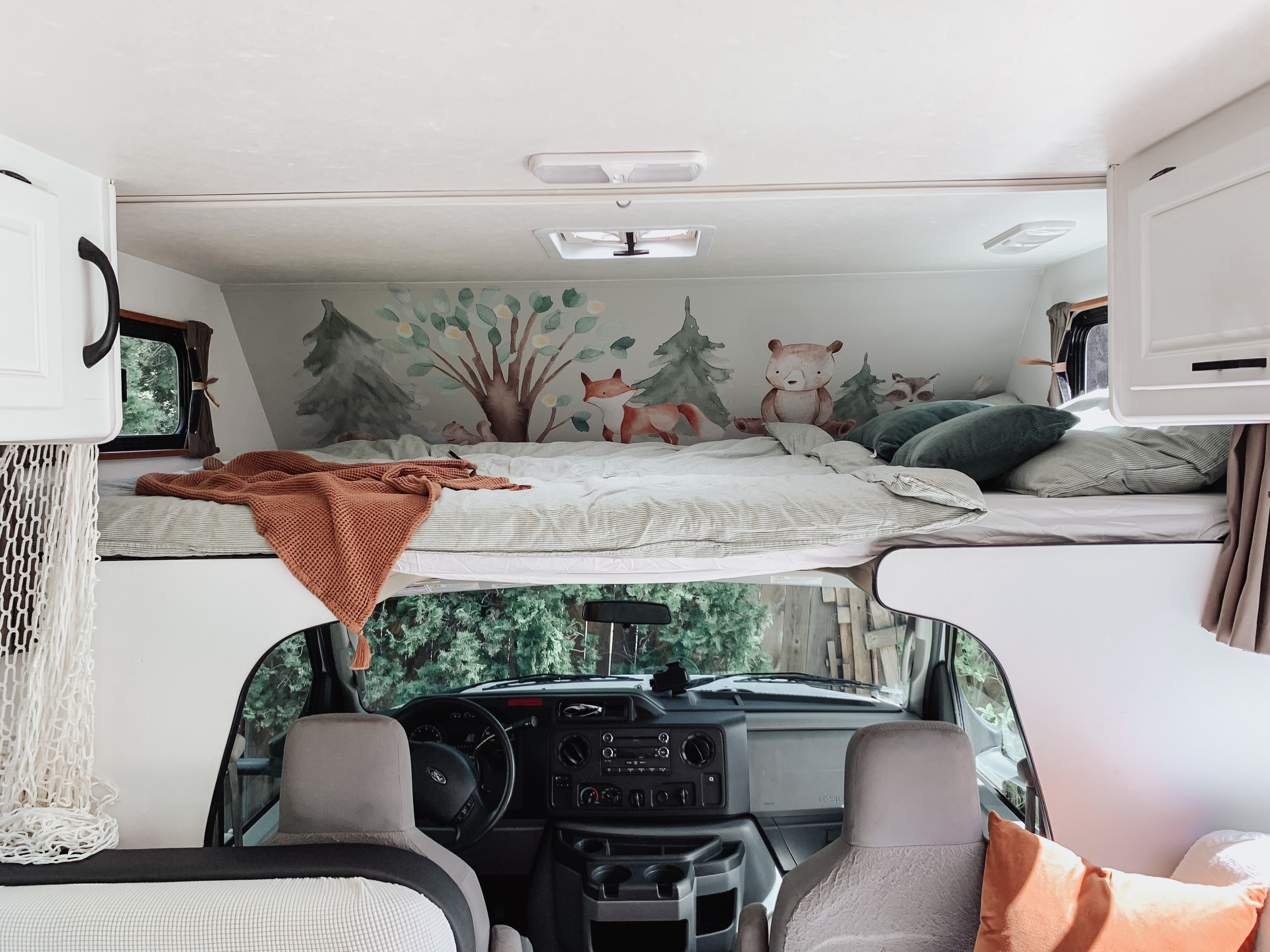 Step inside this cozy rv rental! Features an over-cab bed with a forest animal mural (fox, bear, raccoon), cozy bedding, and front cab below.. Thor Majestic 2017