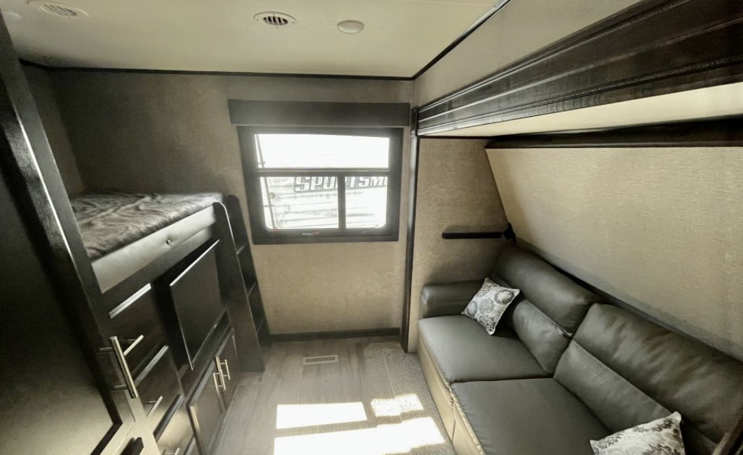 Explore this RV rental's interior: a cozy bunk bed, comfortable sofa, and bright window. Great family space.. Jayco Eagle HT 2020
