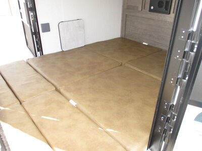 RV rental: Inside a camper, light brown cushions form a large, modular bed/lounge space. Wall table seen.. Forest River No Boundaries NB10.6 "Toy Hauler" 2020
