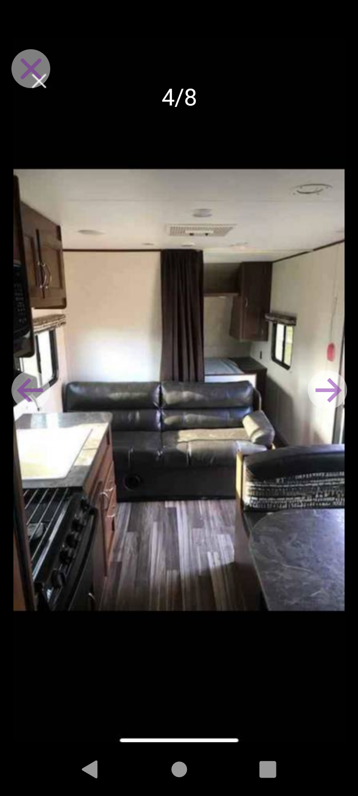 RV rental interior featuring a galley kitchen with stove, black leather sofa, and privacy curtain for a rear sleeping nook.. Jayco Jay Flight SLX 2017