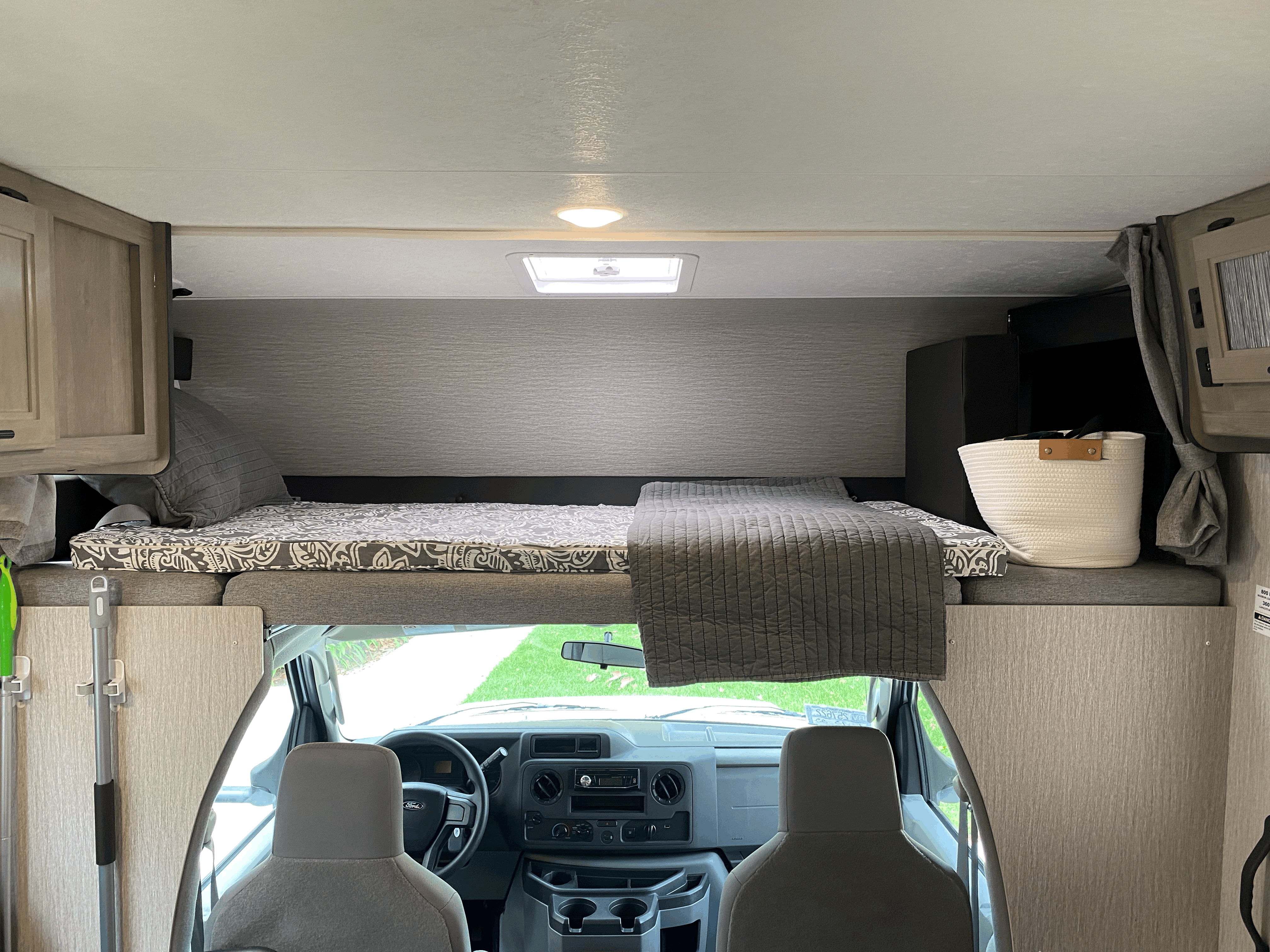 Inside an **RV rental**: a comfortable cab-over bunk and driver's area, showcasing the functional living space.. Forest River Coachmen Cross Trail XL 2022