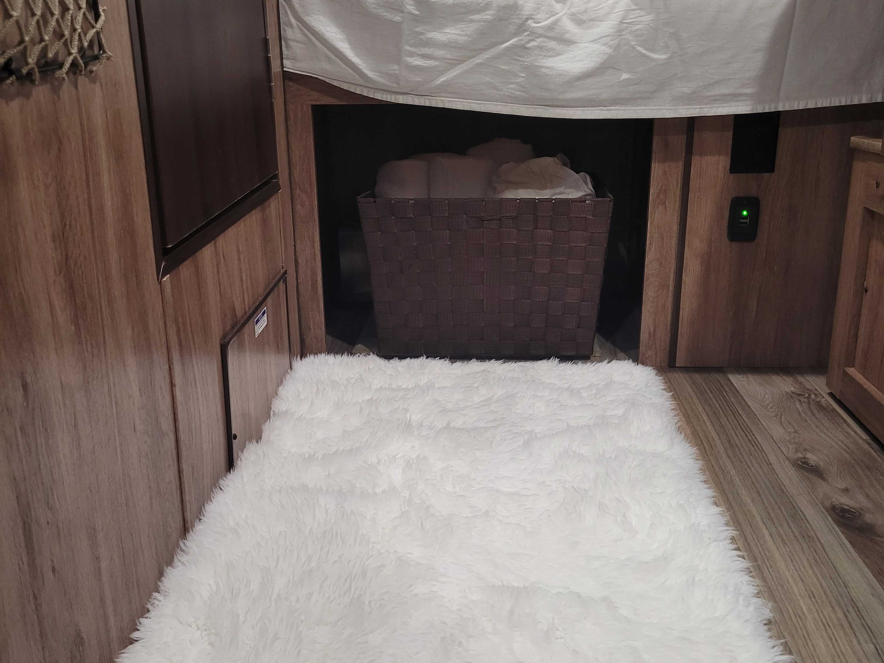 RV rental interior featuring a soft white rug, under-bed storage basket, and USB charging station for comfort & convenience.. Jayco Hummingbird 2018