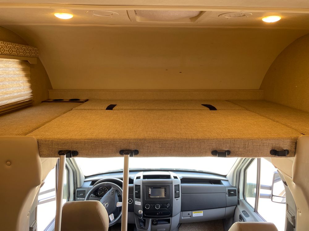 Spacious RV rental cab-over bunk, offering a comfortable sleeping area above the driver's cockpit.. Thor Freedom Elite 2018