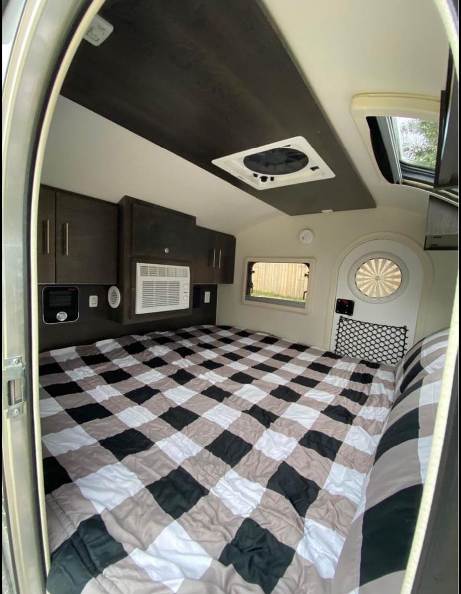 This RV rental's sleeping area features a large checkered bed, AC, overhead storage & vent.. NuCamp T@G MAX XL BOONDOCK 2021
