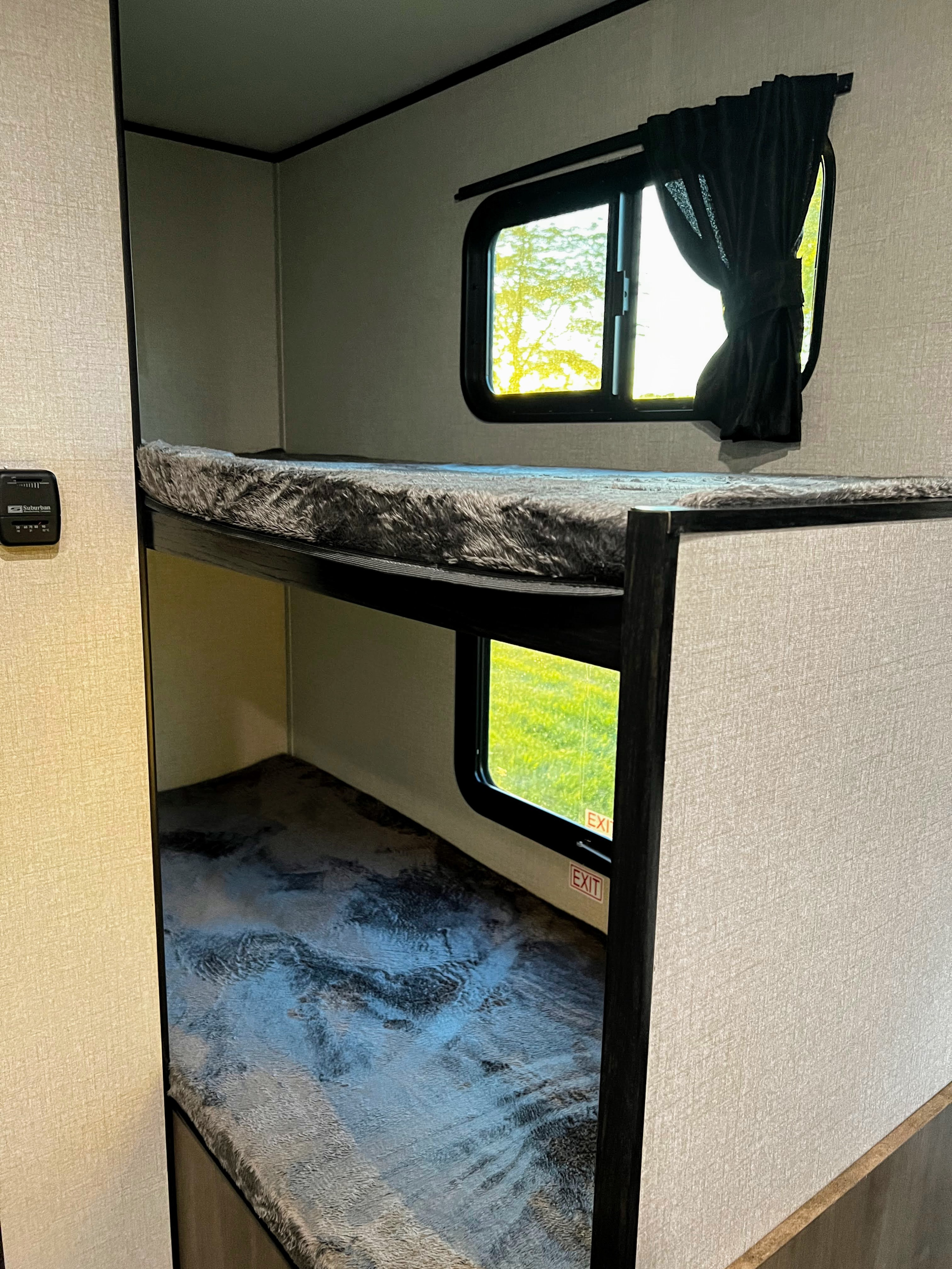 RV rental bunk beds feature cozy mattresses, windows with outdoor views, blackout curtains, and an accessible thermostat.. Open Range Open Range 2022