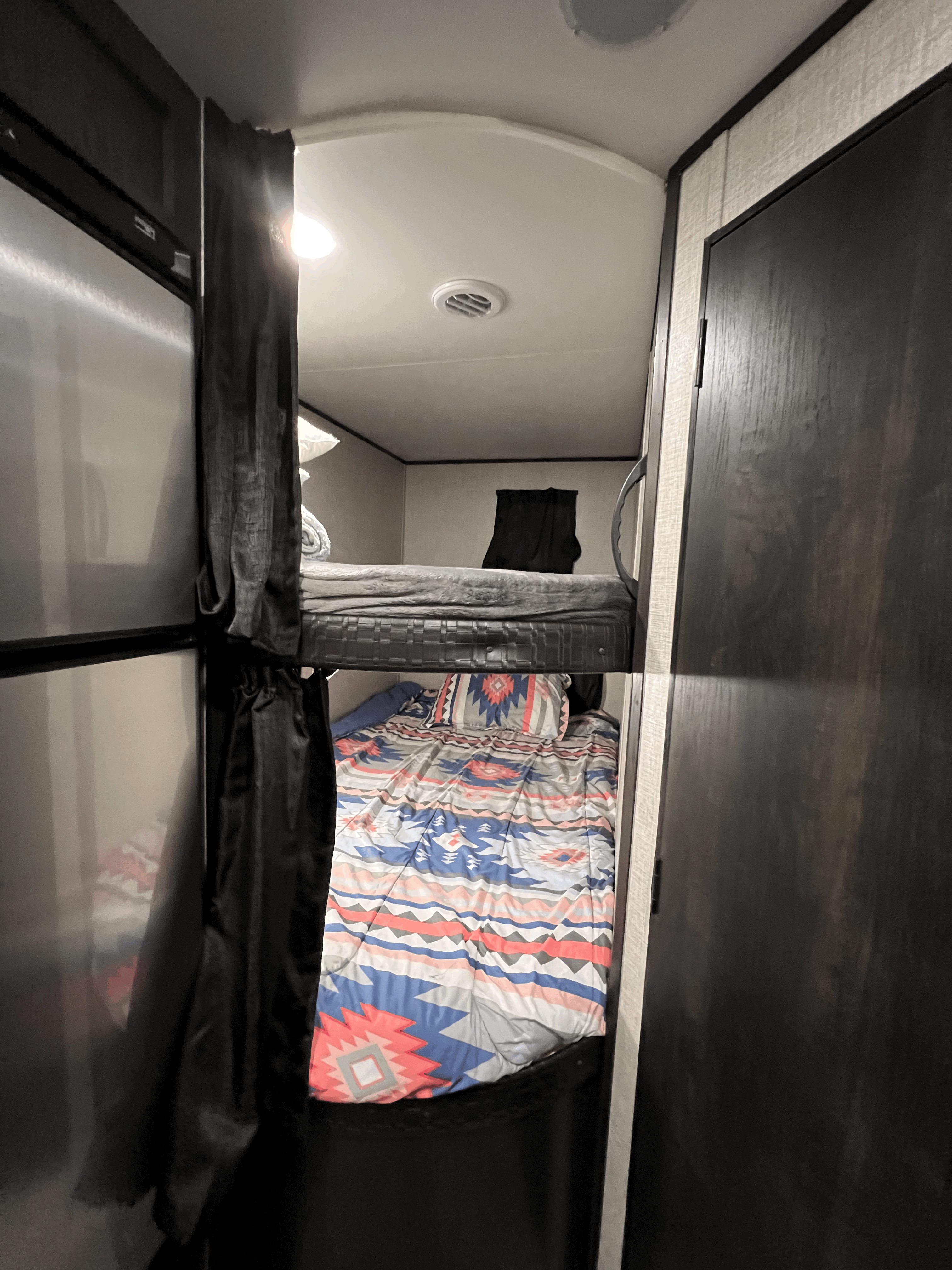Cozy RV rental interior with bunk beds, featuring a colorful blanket, ideal for family camping trips.. Jayco Jay Flight SLX 8 2022