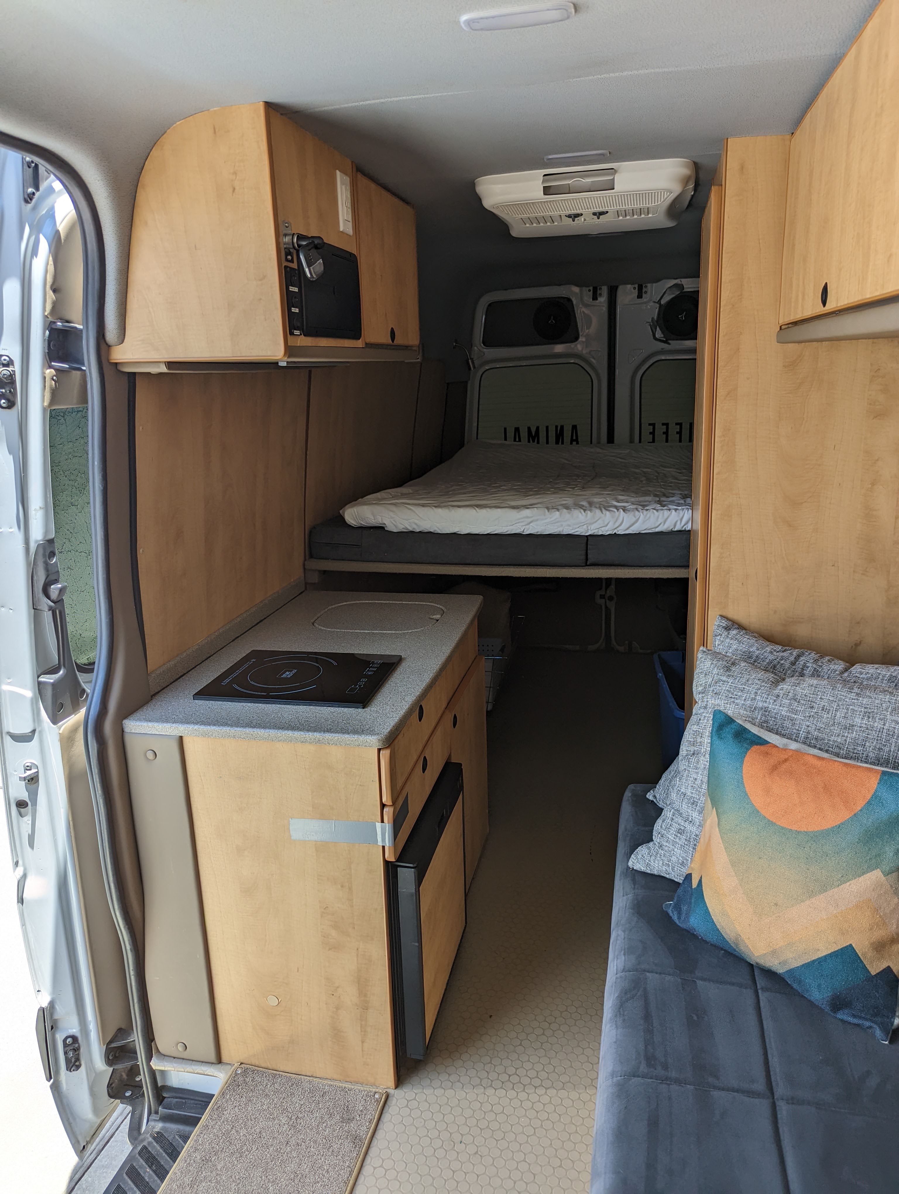 Explore this comfy RV rental camper van interior. Features a kitchen, bed, and cozy living area, perfect for road trips.. Freightliner Sprinter Van 2012