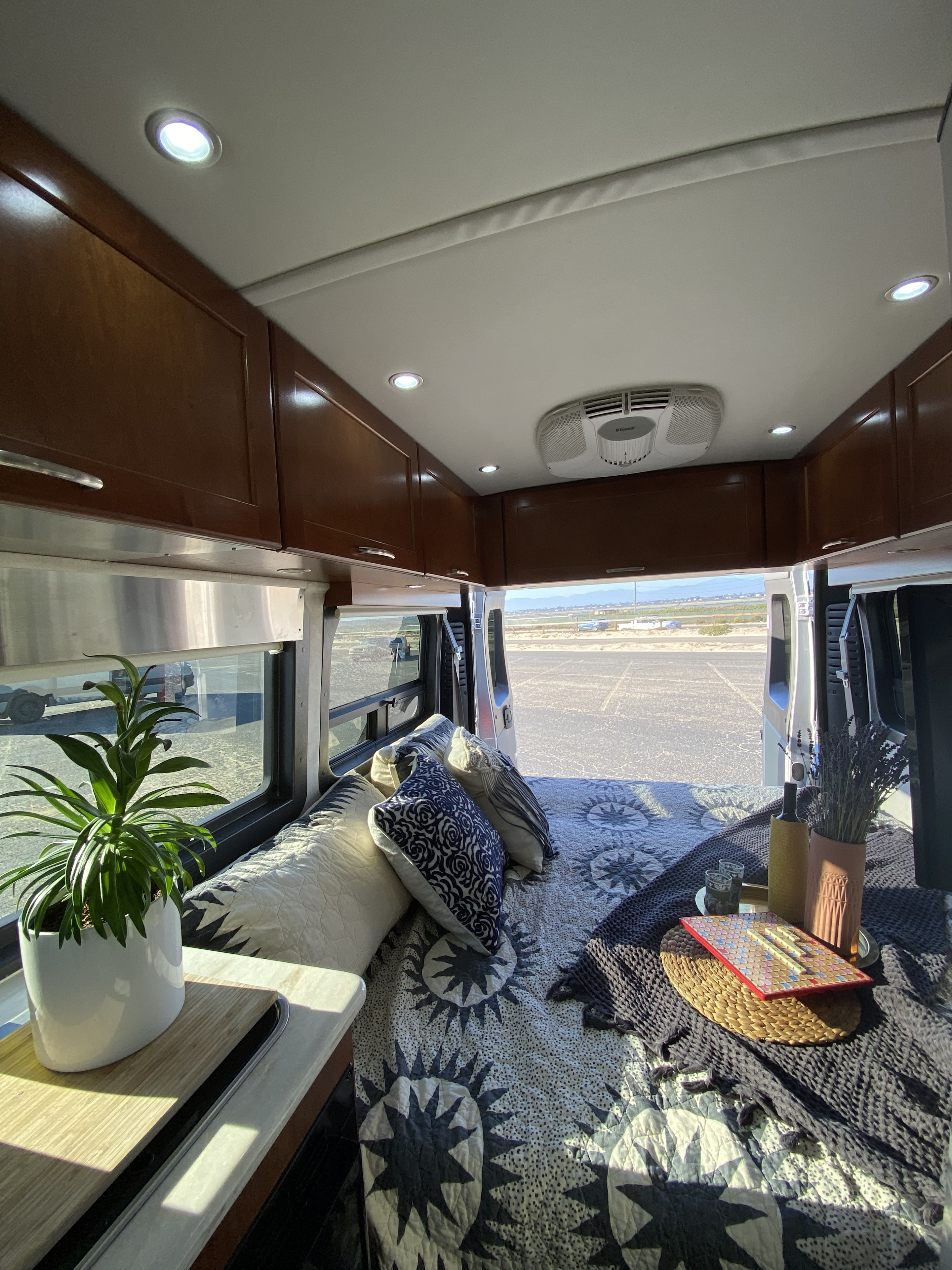 Step into comfort: a spacious RV rental interior featuring a cozy bed, ambient lighting, and open back view.. Pleasure-Way Pleasure-Way Class B 2016
