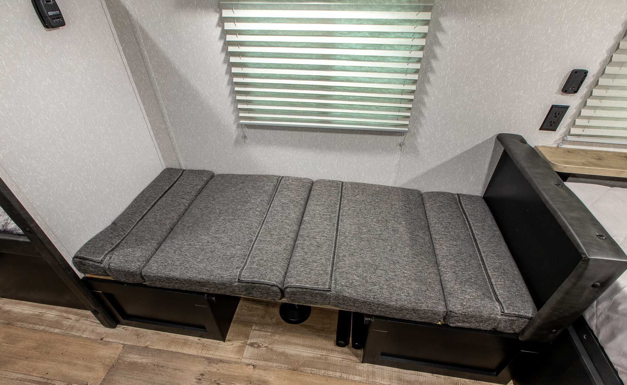 RV rental: Grey cushioned bench seating, often convertible to a bed, with window blinds above.. Forest River Cherokee Wolf Pup 2022