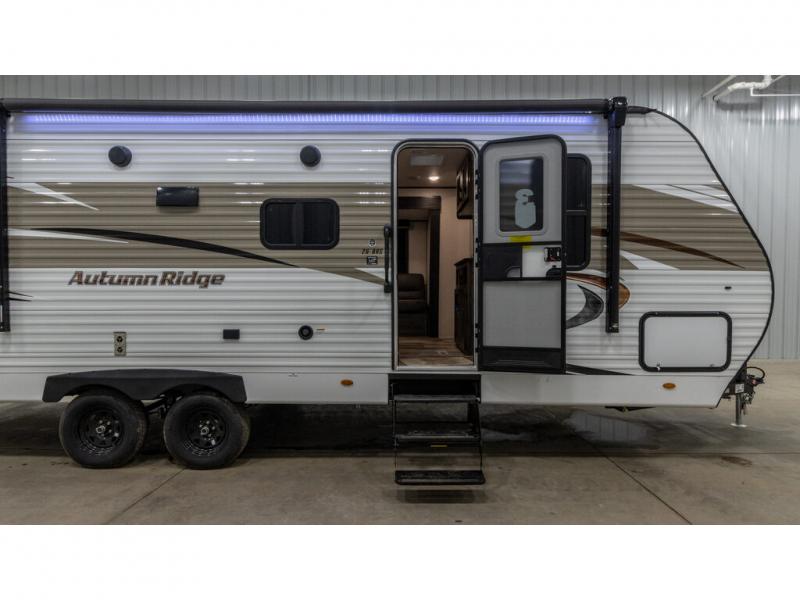 Autumn Ridge travel trailer, perfect for your next RV rental. Open door reveals a peek inside this adventure-ready camper.. Autumn Ridge 26BHS 2022