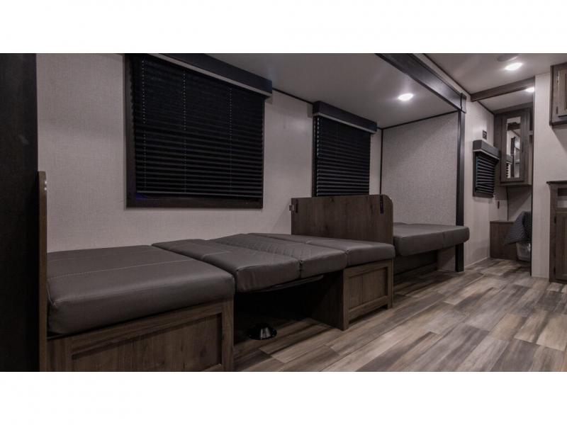 This RV rental features a versatile interior with convertible bench seating, wood-look floors, and window blinds.. Autumn Ridge 26BHS 2022