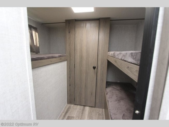 RV rental bunkhouse with multiple bunk beds and a central storage closet. Features wood-look flooring for compact family sleeping.. Gulf Stream Ameri-Lite 2022