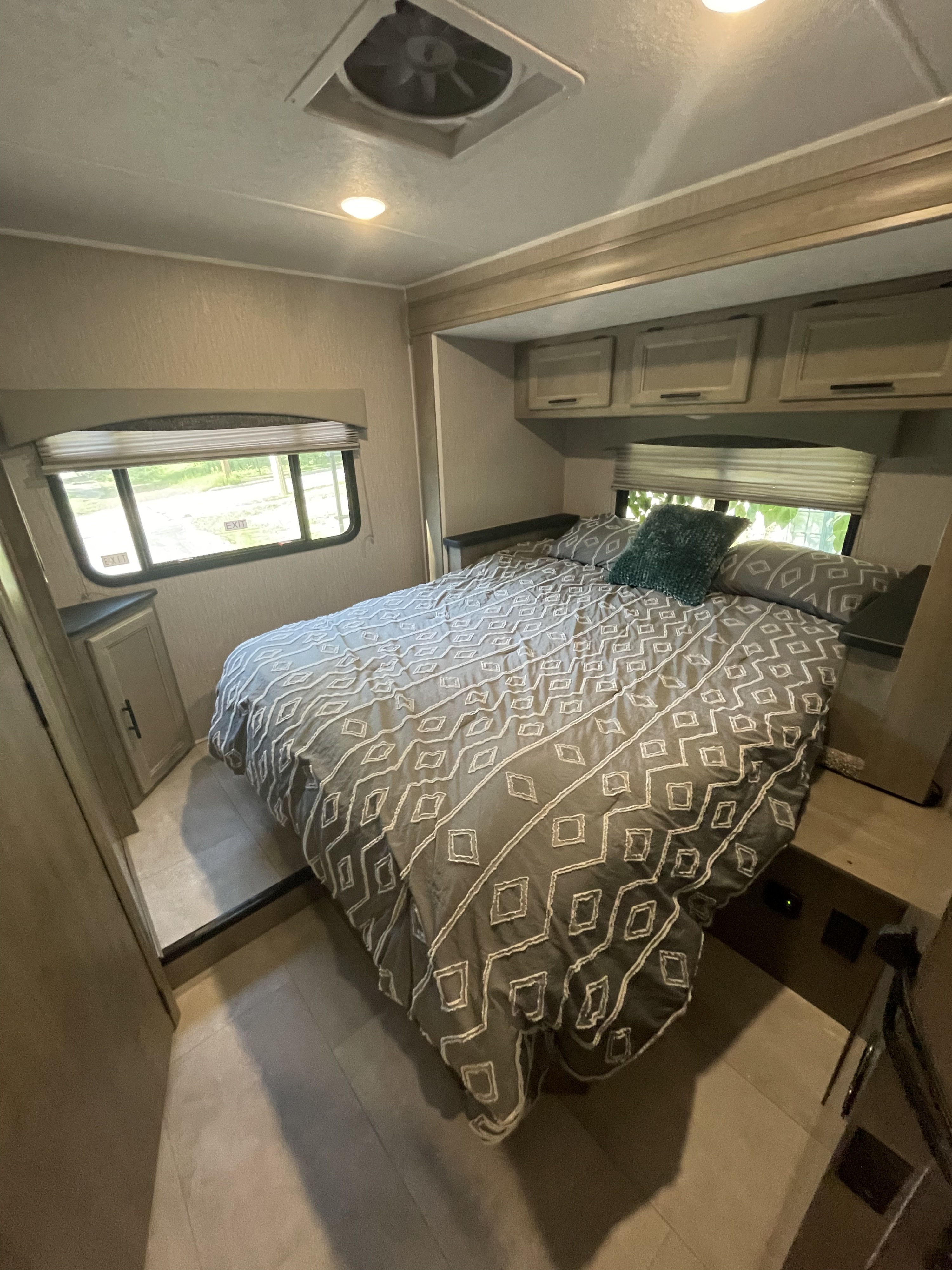 Cozy RV rental bedroom with patterned bed, overhead storage, and exit windows. Perfect for your next adventure.. Other Other 2022