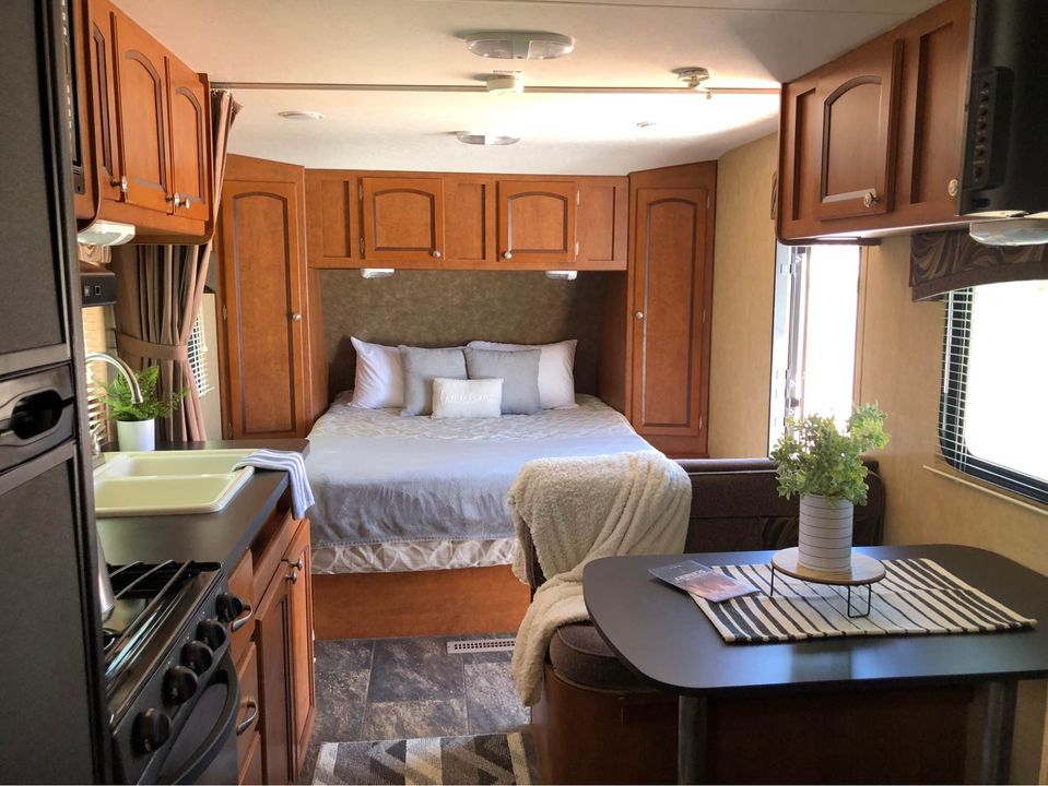 Explore this rv rental's interior, featuring a cozy bedroom, a practical kitchen with sink/stove, and a functional dining area.. Forest River Shasta Freeport 2012