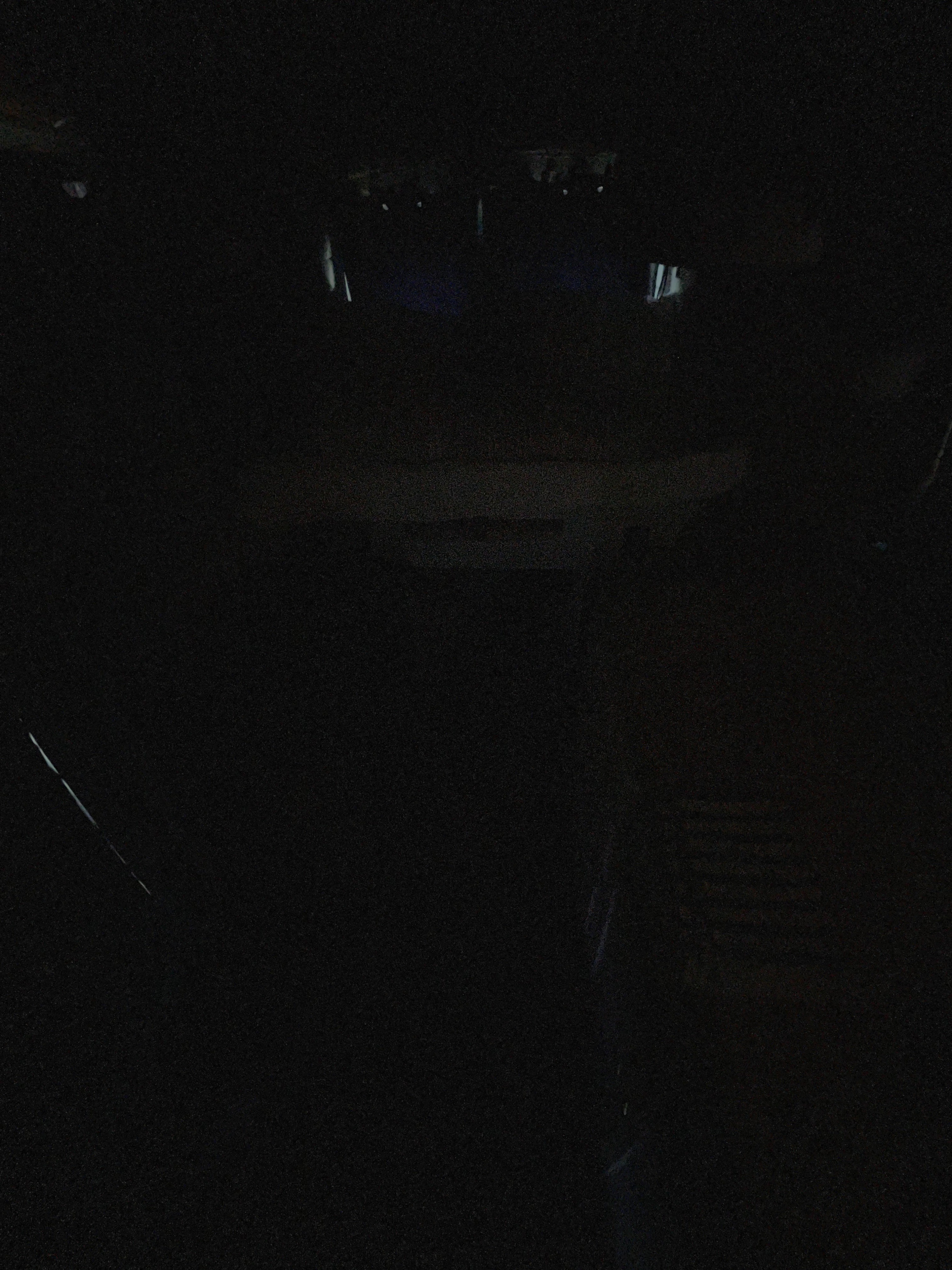 Extremely dark RV rental interior at night, with only faint outlines of the cabin visible.. Ford Custom Transit 2018