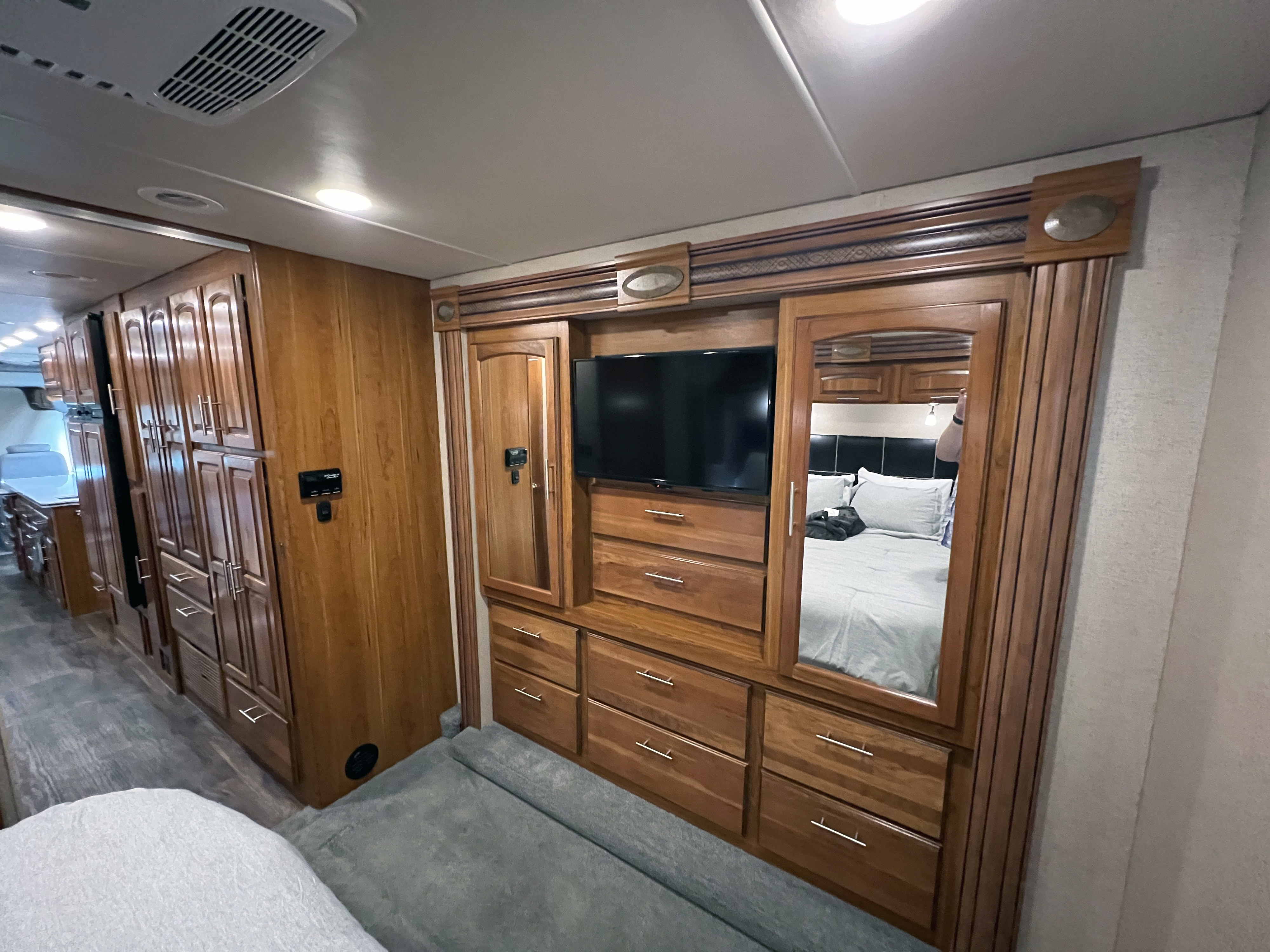 Explore this RV rental's well-appointed interior featuring rich wooden cabinetry, built-in TV, and mirrored bedroom closet.. Jayco Precept 2016