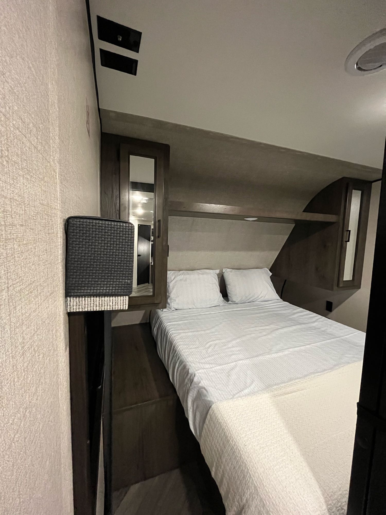 Cozy RV rental bedroom with white bed, overhead cabinets, mirrored storage, and TV mount prepped ceiling.. Other Other 2022