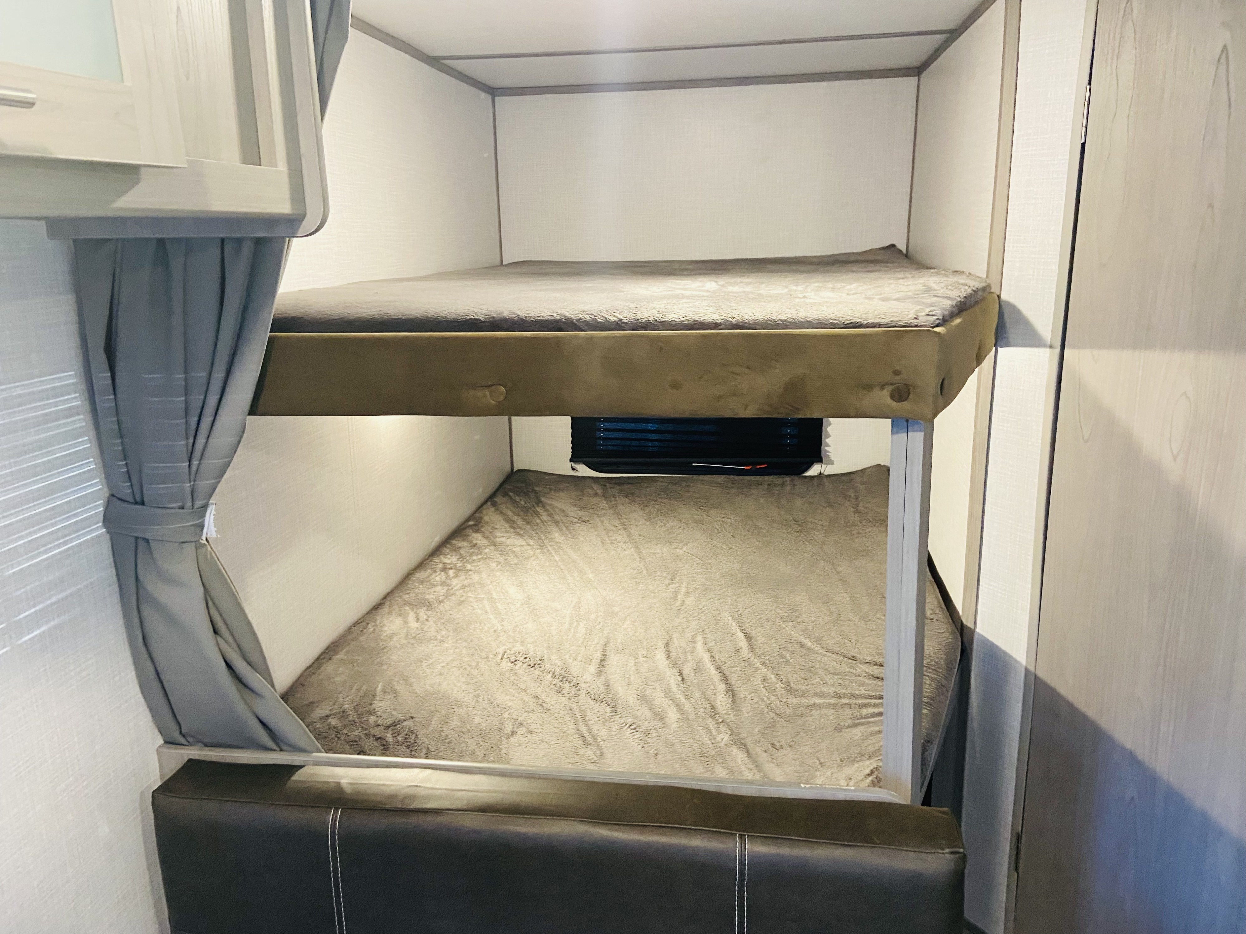 Comfortable bunk beds inside an RV rental, perfect for family travel accommodations.. Dutchmen bh18 2022