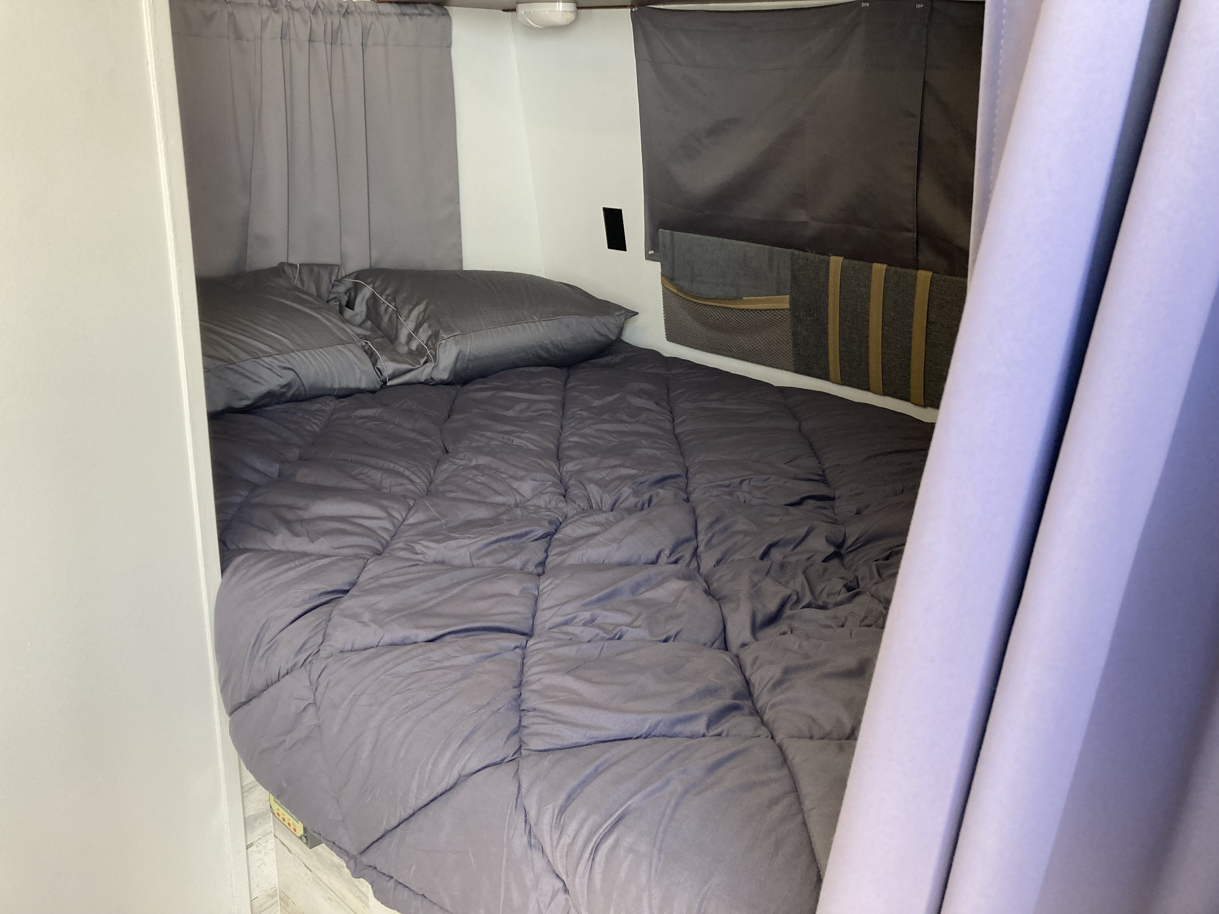 Cozy RV rental bed with gray bedding,. KZ Spree Escape 204S 2015