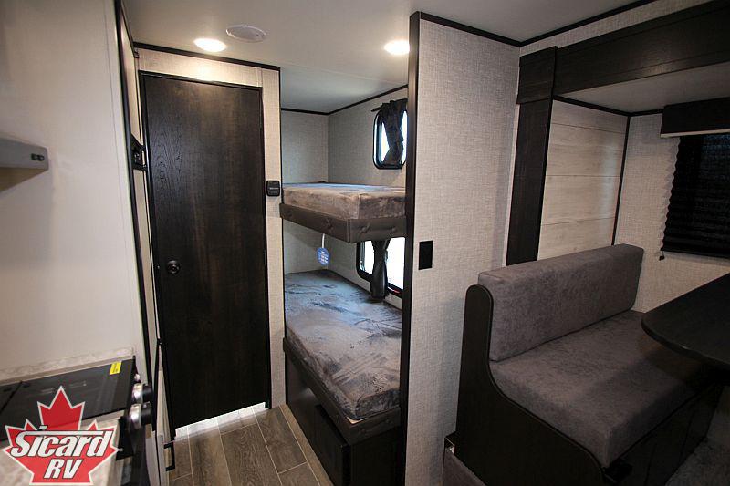 RV rental: Spacious interior featuring a private bunk bed area, a closed door, and comfortable dinette seating.. Jayco Jay Flight SLX7 184bs 2022