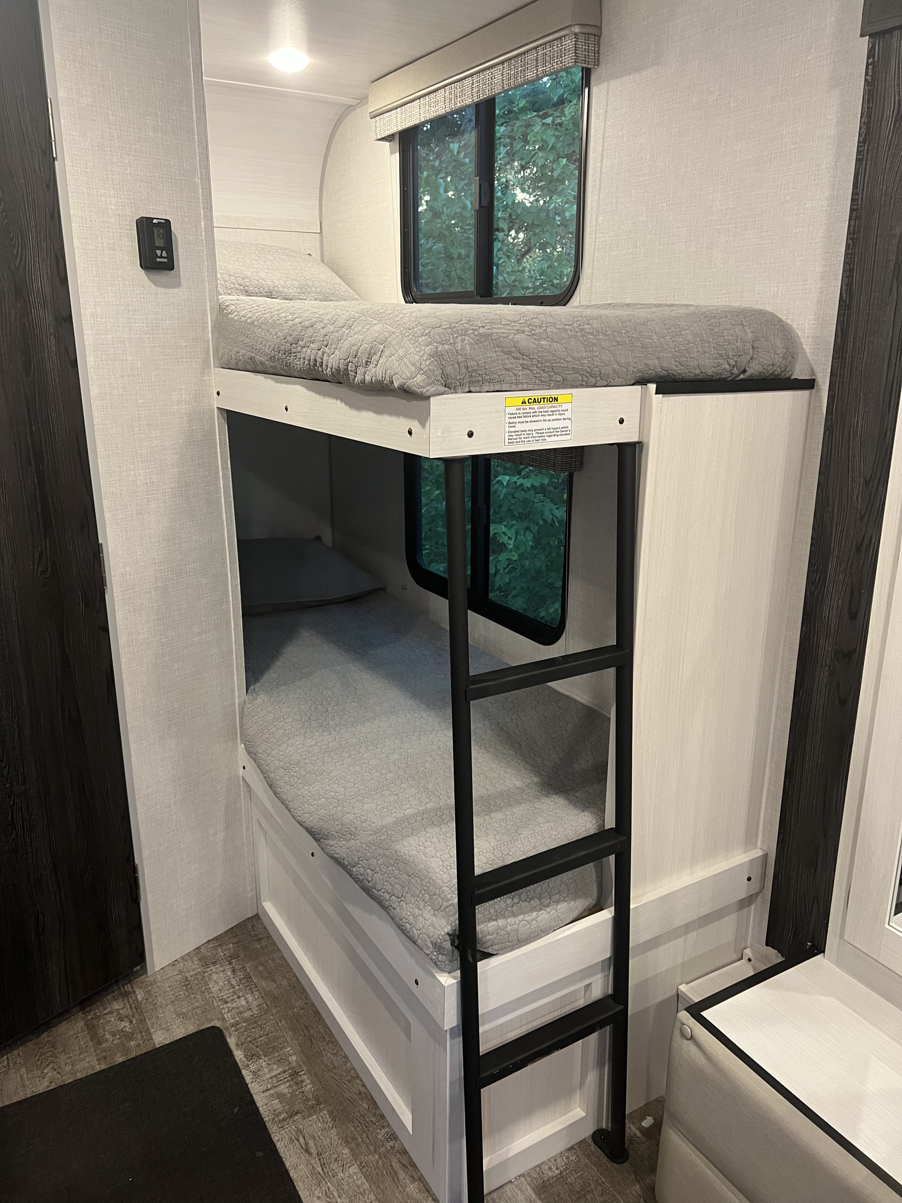 Cozy RV rental bunk beds with windows, perfect for family adventures. Safety-first design in this spacious RV interior.. Forest River R-Pod 193 2022