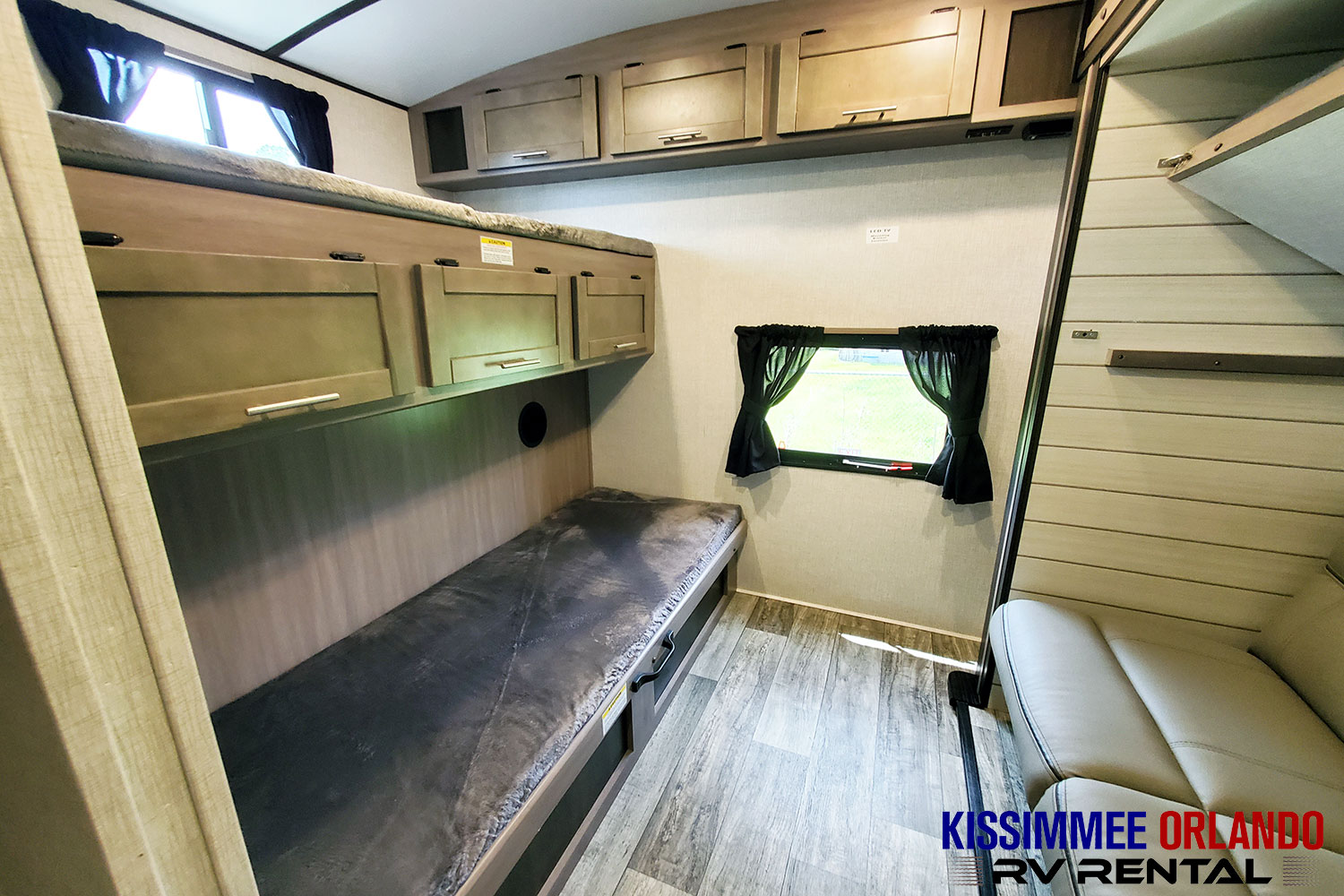 RV rental interior featuring comfortable bunk beds, overhead storage, and a cozy window area.. Crossroads Sunset Trail 2022