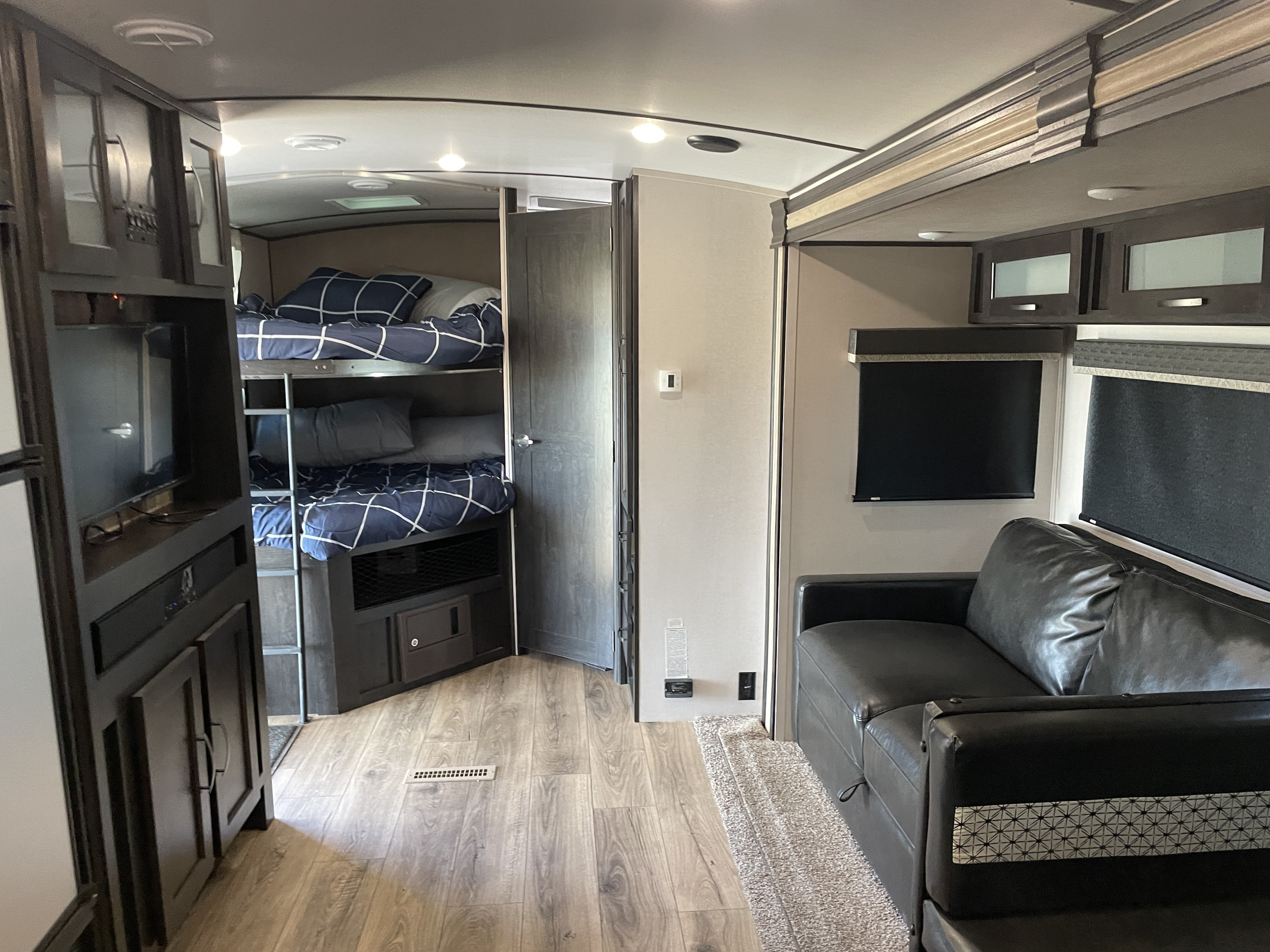 Inside an RV rental: Features include bunk beds, a comfy sofa, and media center, creating a functional living space.. FOREST RIVER 287BHSS 2020