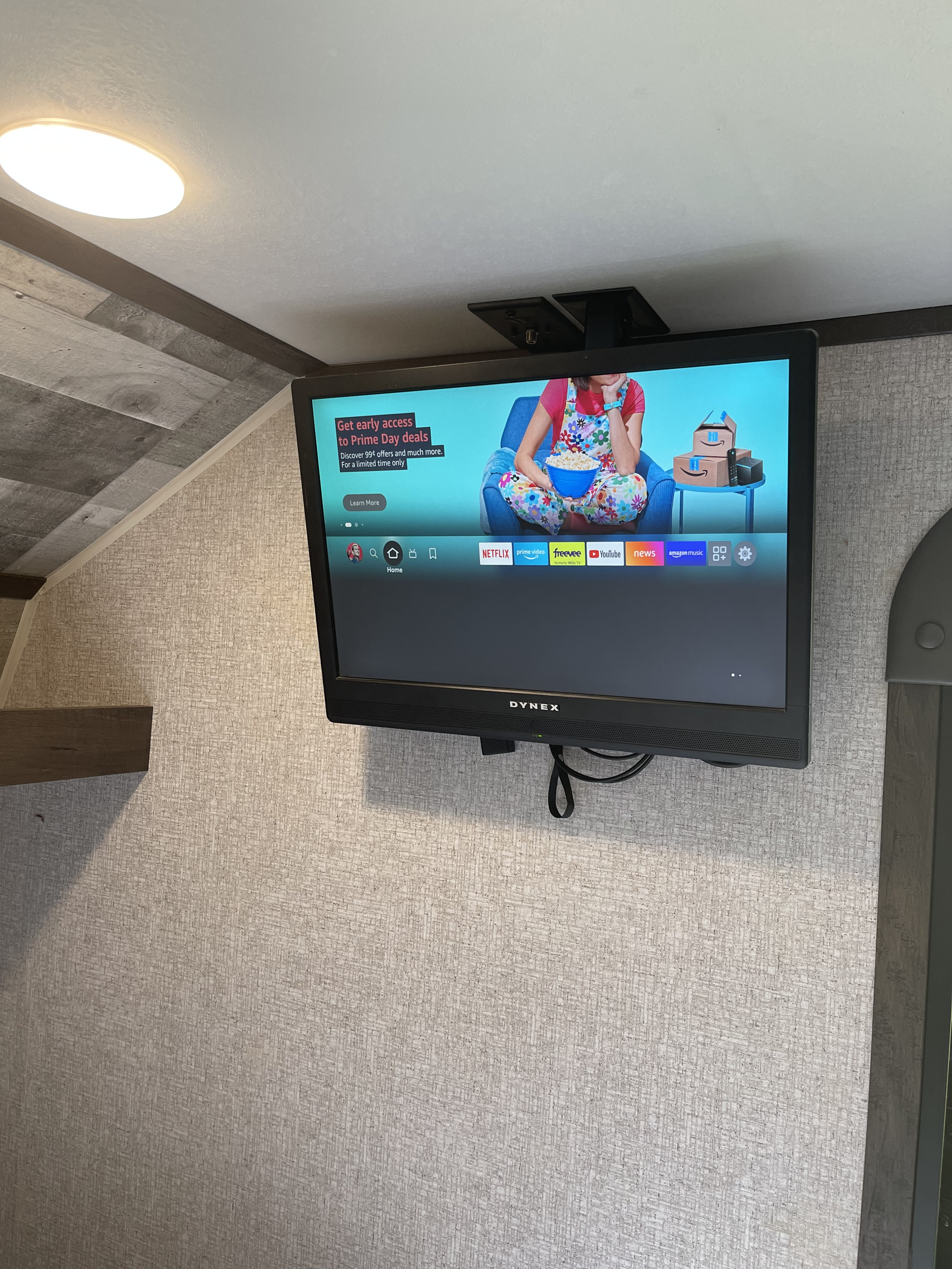 RV rental interior featuring a mounted TV displaying streaming services like Netflix & Prime Video, perfect for entertainment on the go.. Dutchmen Coleman Lantern LT 2021