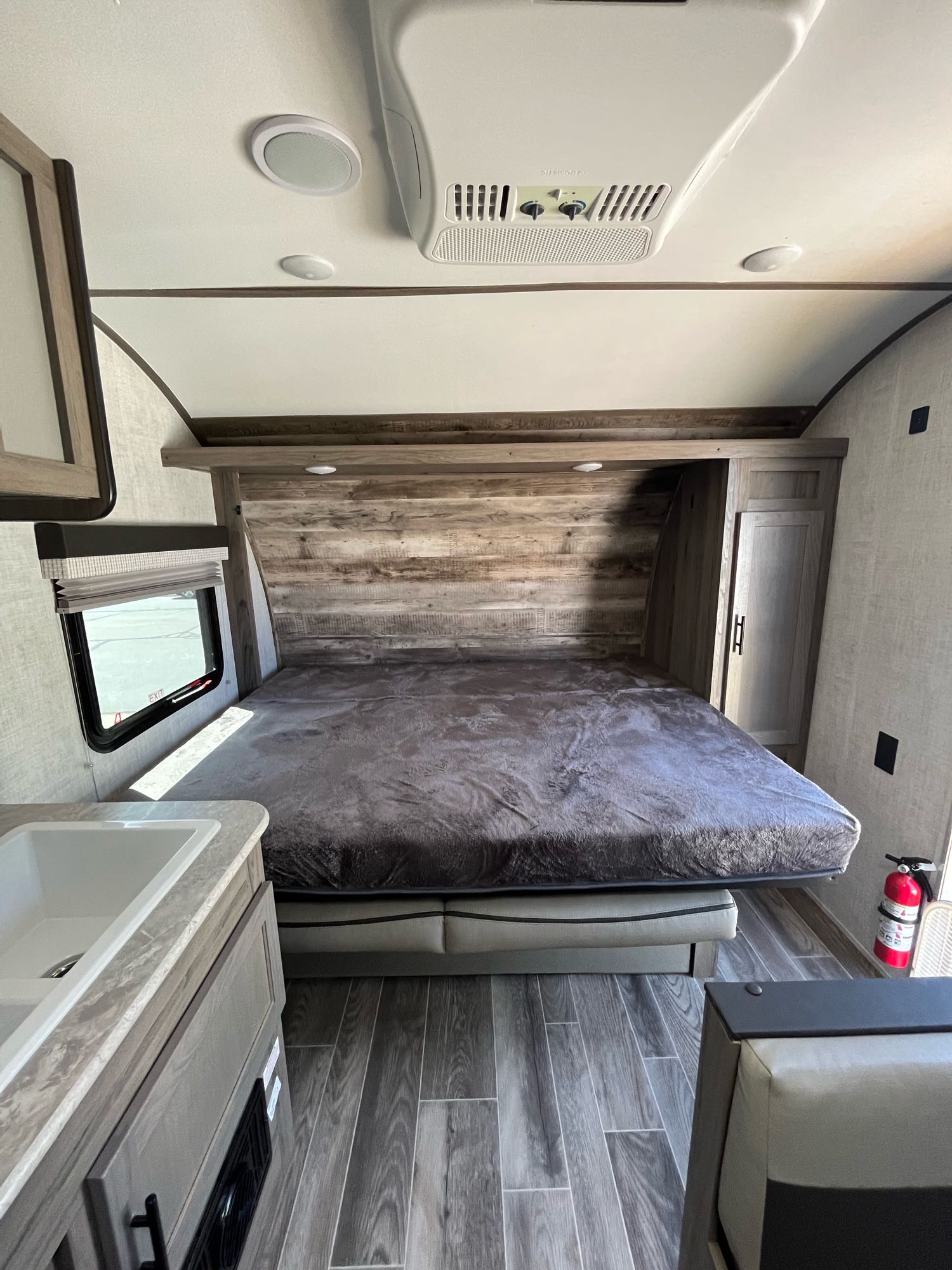 RV rental interior: a comfy bedroom with a large bed, rustic wood accent wall, and handy sink. Ready for your adventures.. Gulf Stream Other 2022