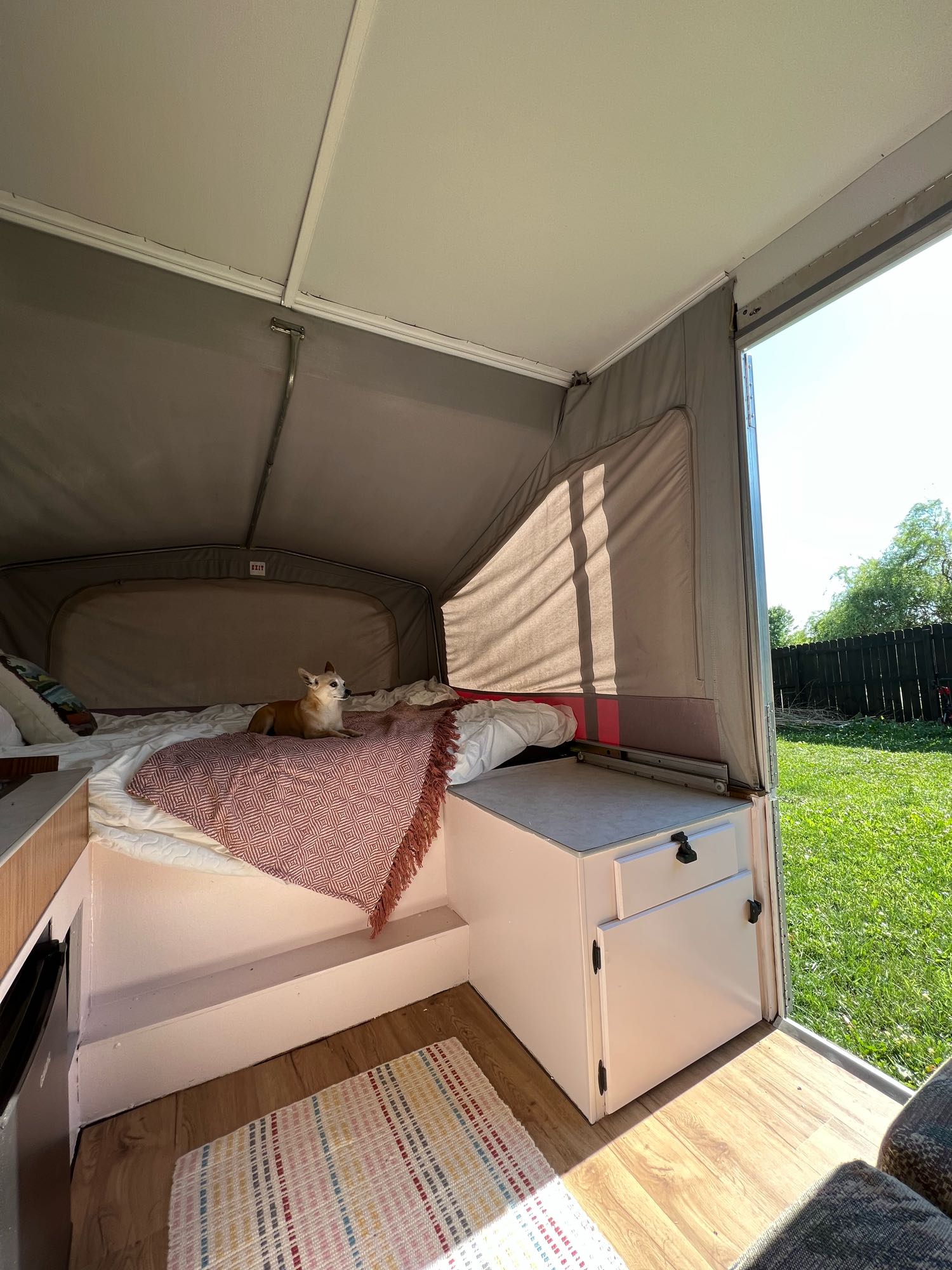 Cozy RV rental interior shows a bed with a dog, ready for travel adventures and outdoor living.. Jayco Eagle 1996