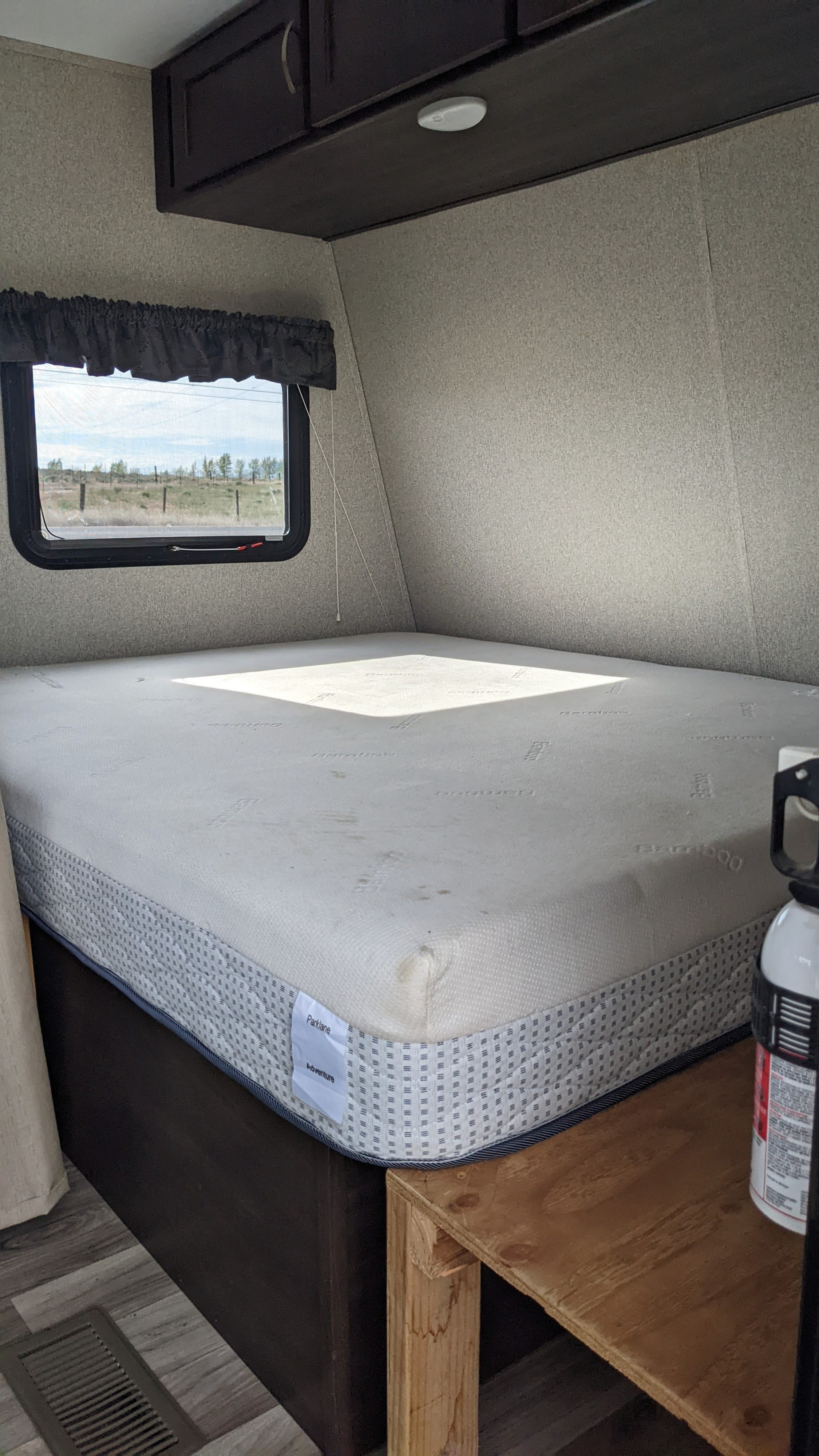 This RV rental features a comfortable bed with an Adventure mattress, window view, overhead storage, and a fire extinguisher.. Keystone RV Springdale 2019