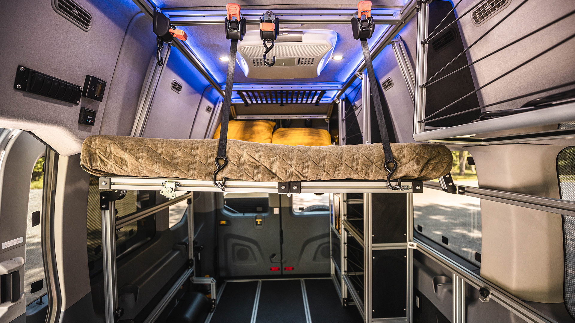 RV rental: Modular camper van interior with a raised bed, AC, controls, and smart storage.. Ford Transit 2021