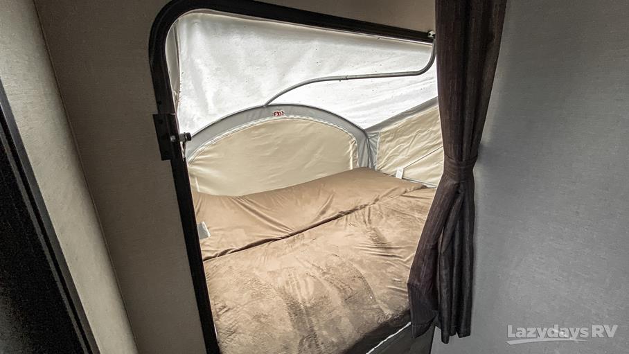 Cozy RV rental sleeping area, an expandable bed with brown bedding, inside a camper.. K-Z Manufacturing Escape 2017