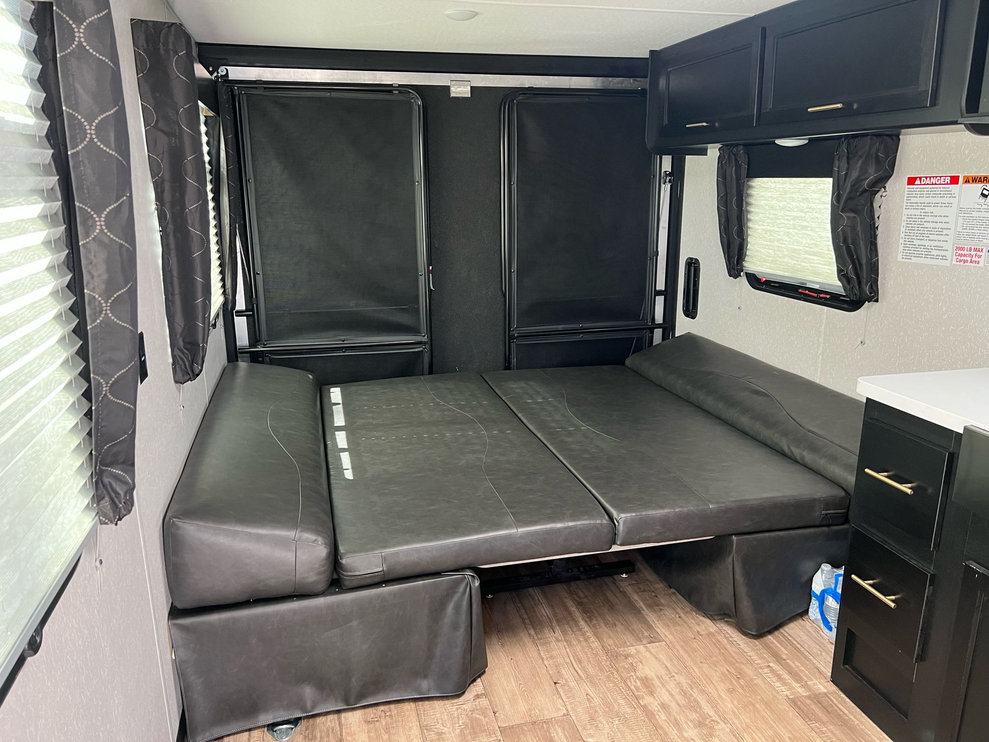 RV rental garage area with a comfortable convertible bed and overhead storage. Ideal for adventurers.. Forest River Cherokee Grey Wolf 2022