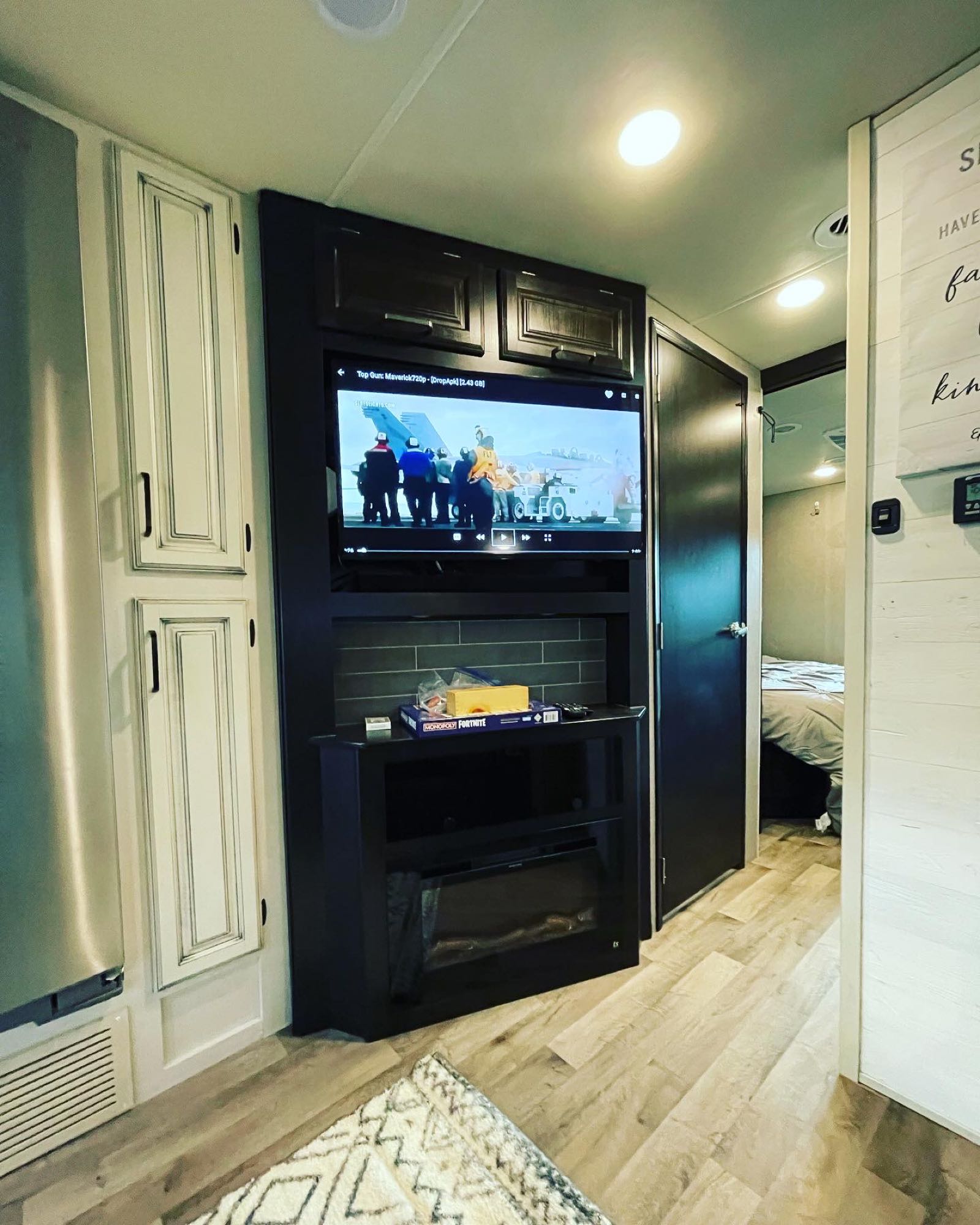 Cozy RV rental interior featuring a TV, electric fireplace, and a peek into the bedroom. Perfect for entertainment on the go!. Jayco Precept 2021