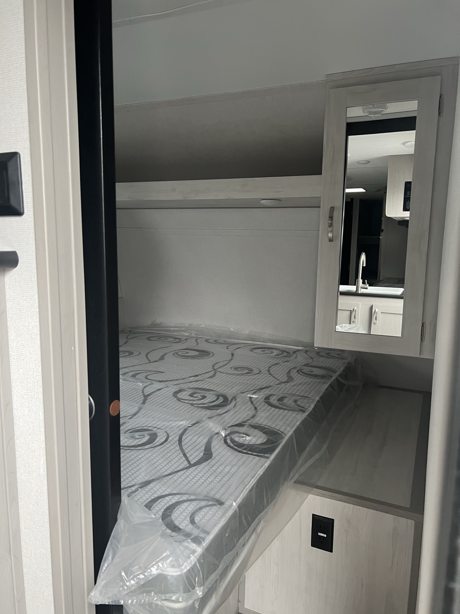 RV rental: Bright bunk bed area with a new mattress and mirror reflecting a kitchen sink.. Primetime Tracer 2022