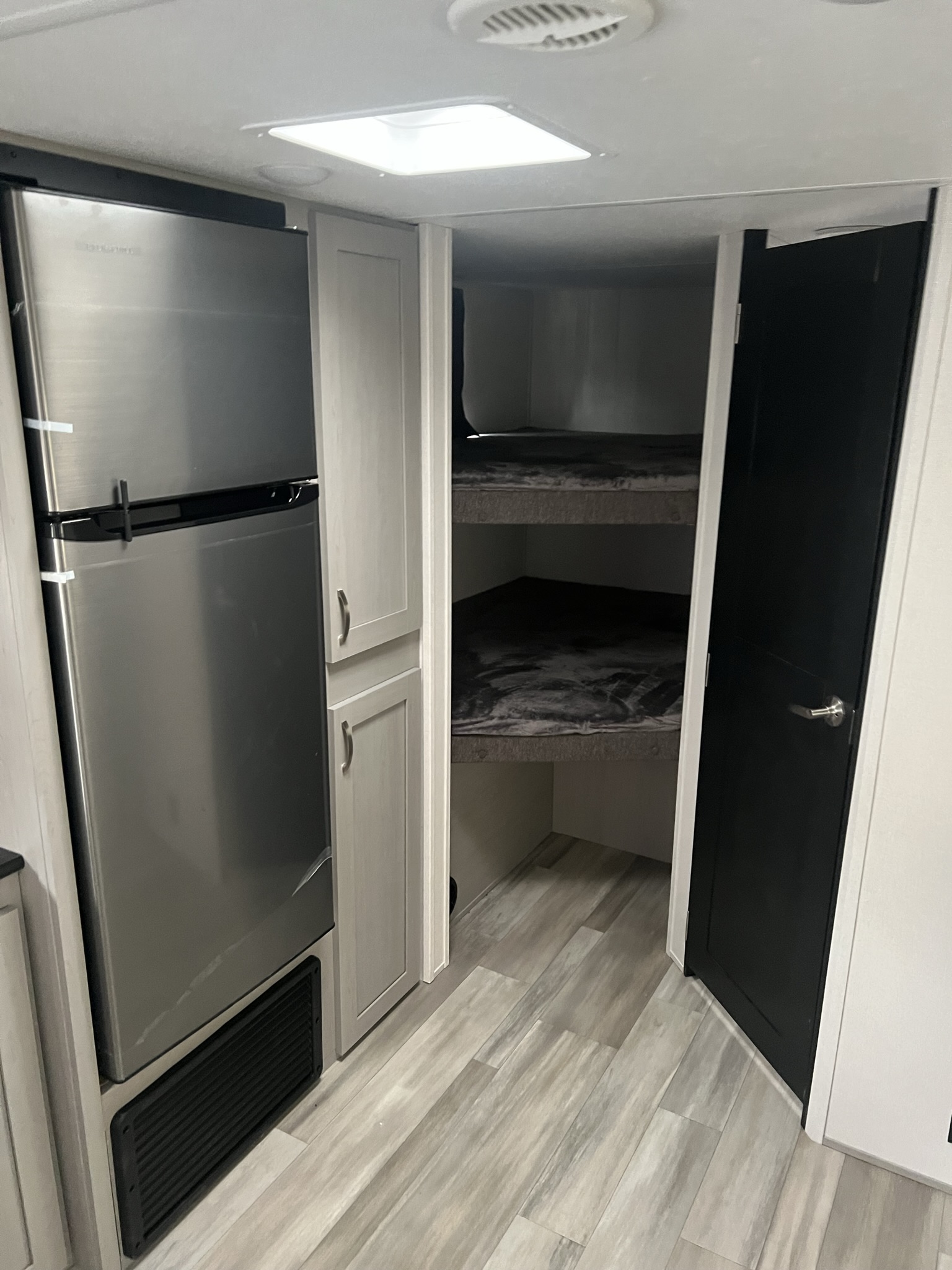 Inside this RV rental: stainless steel fridge, cabinets, and a built-in bunk bed area for extra sleeping.. Primetime Tracer 2022