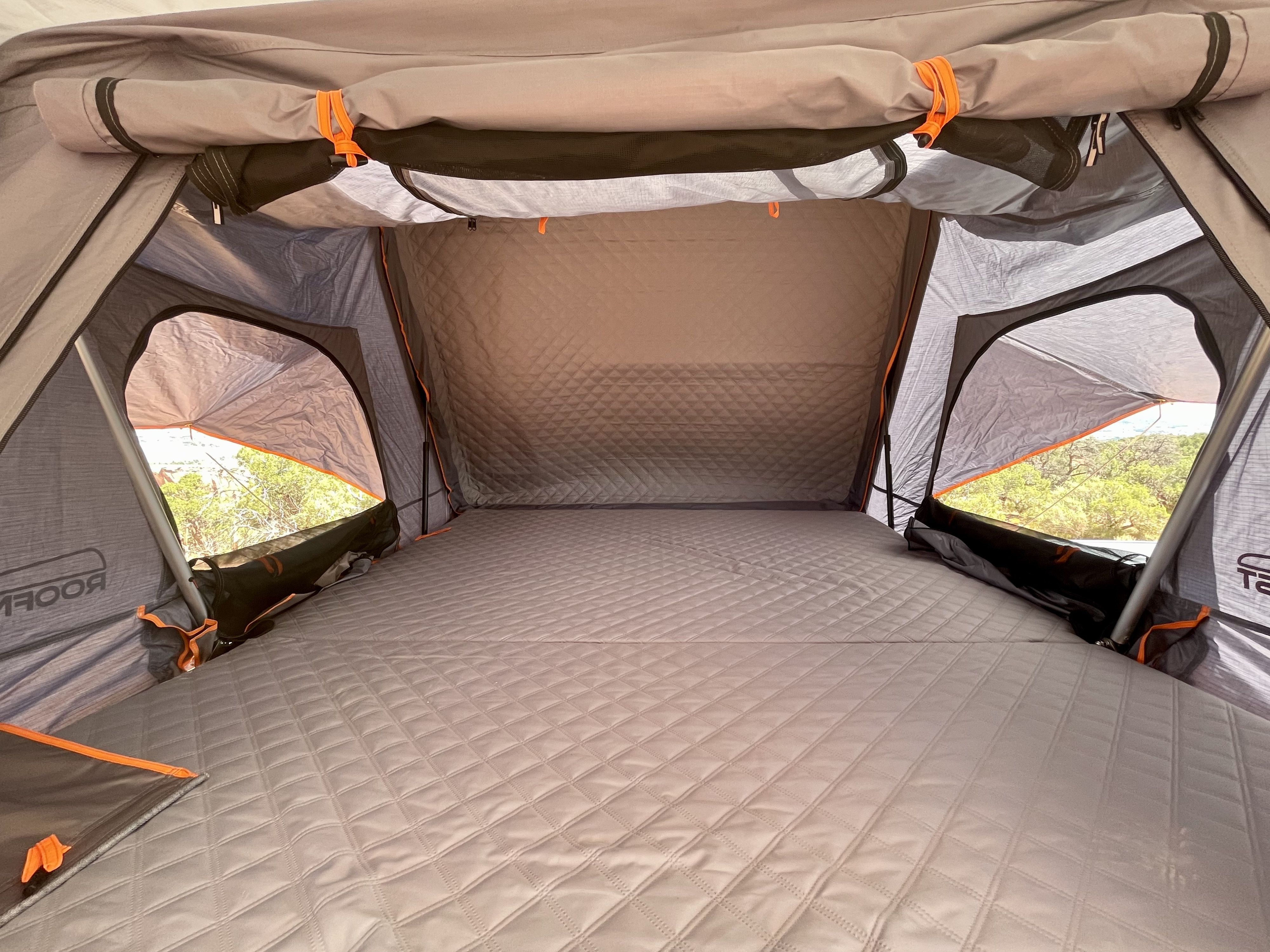 Cozy rooftop tent interior with a quilted mattress, offering comfort for your RV rental camping adventure.. Jeep Gladiator 2021