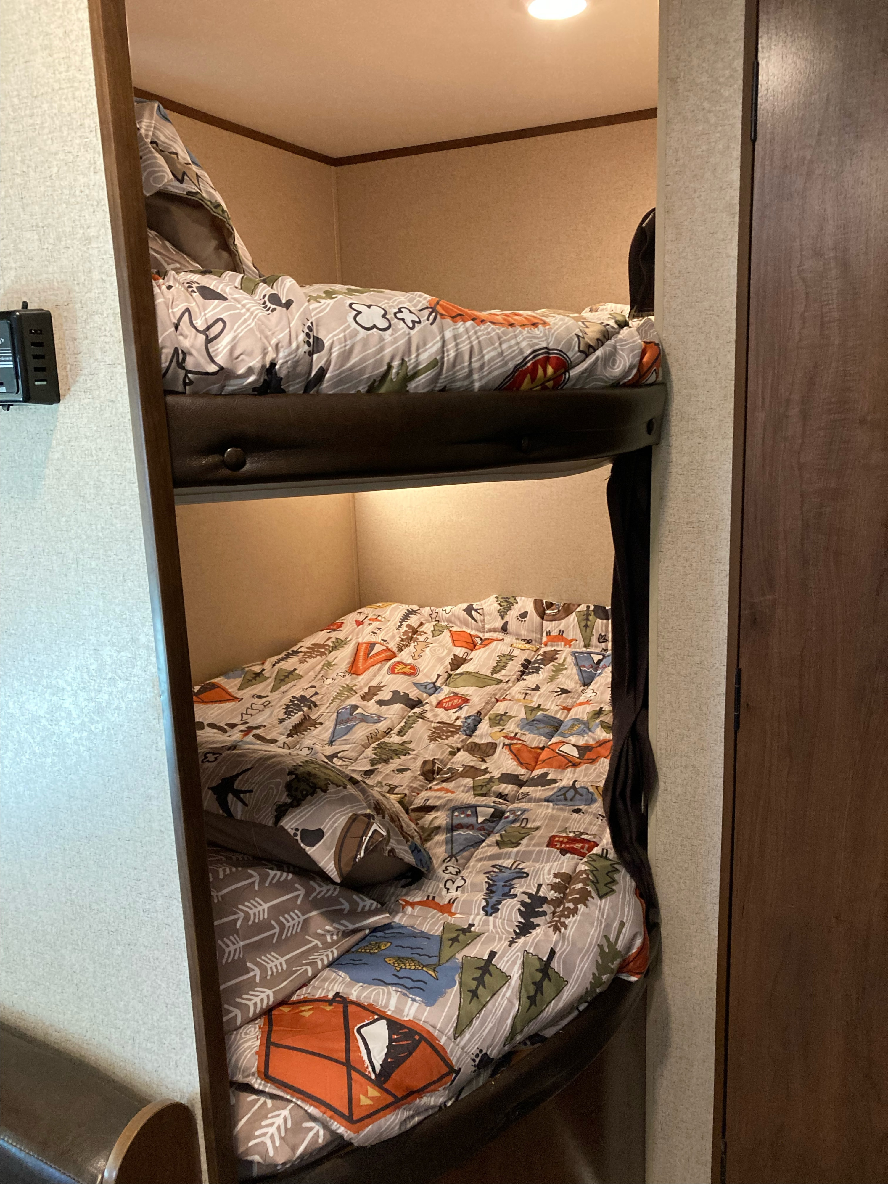 RV rental bunk beds featuring camping-themed bedding, providing a cozy sleeping area for your next adventure.. Jayco Jay Flight SLX 2016
