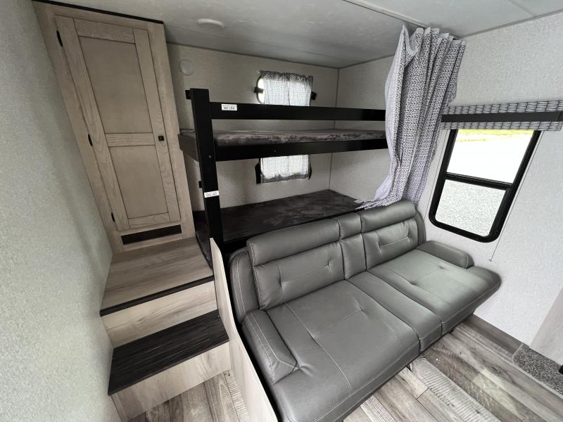 RV rental interior features bunk beds, a comfortable grey sofa, and built-in wooden storage steps for family comfort.. Connect SE 2021