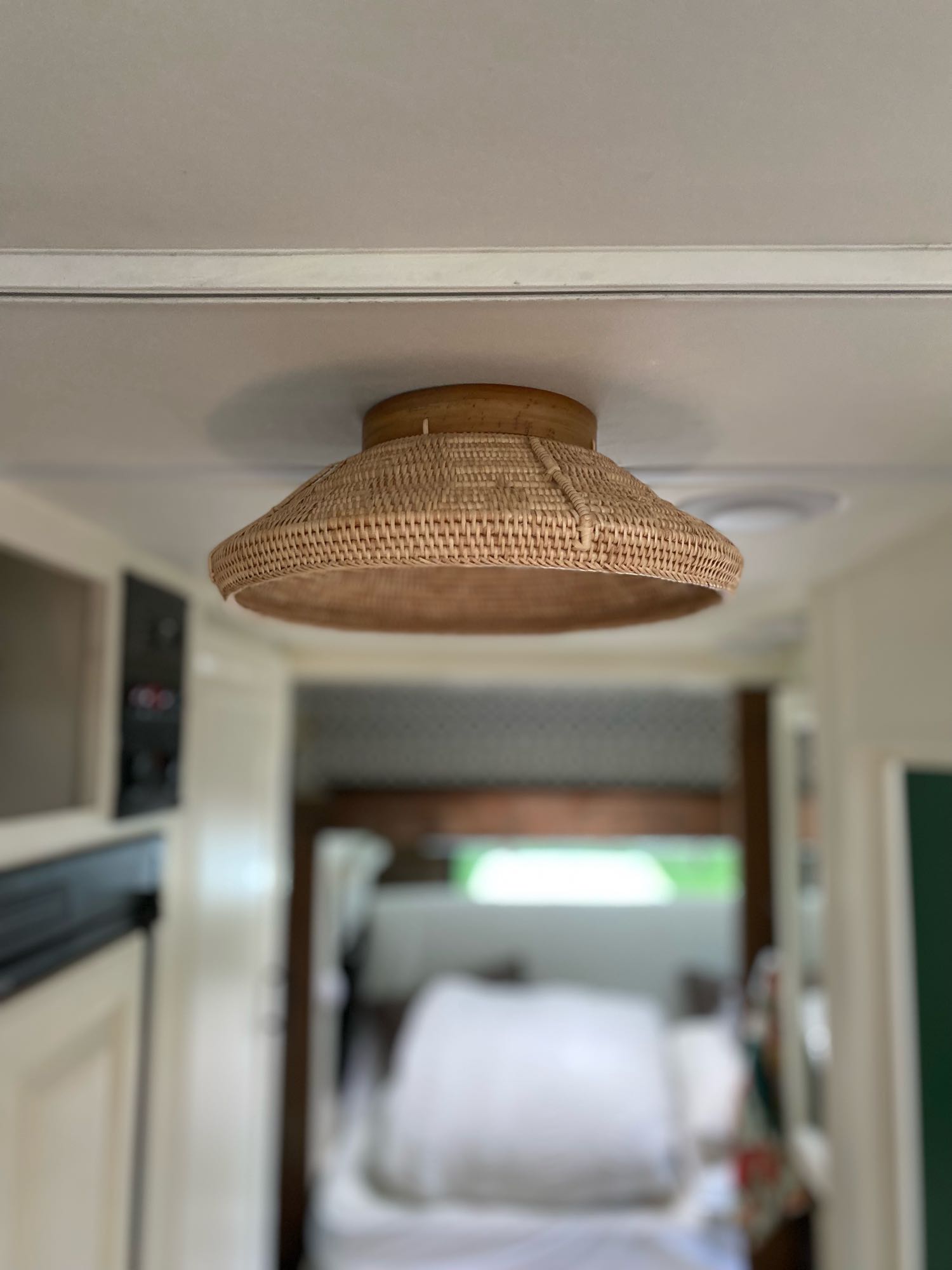 Stylish rattan light fixture on the ceiling of this RV rental, enhancing the cozy interior space.. Forest River Solera 2014