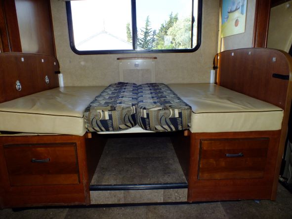 Cozy RV rental dinette converts to a bed, featuring ample storage drawers below and a large window.. Forest River Sunseeker 2015