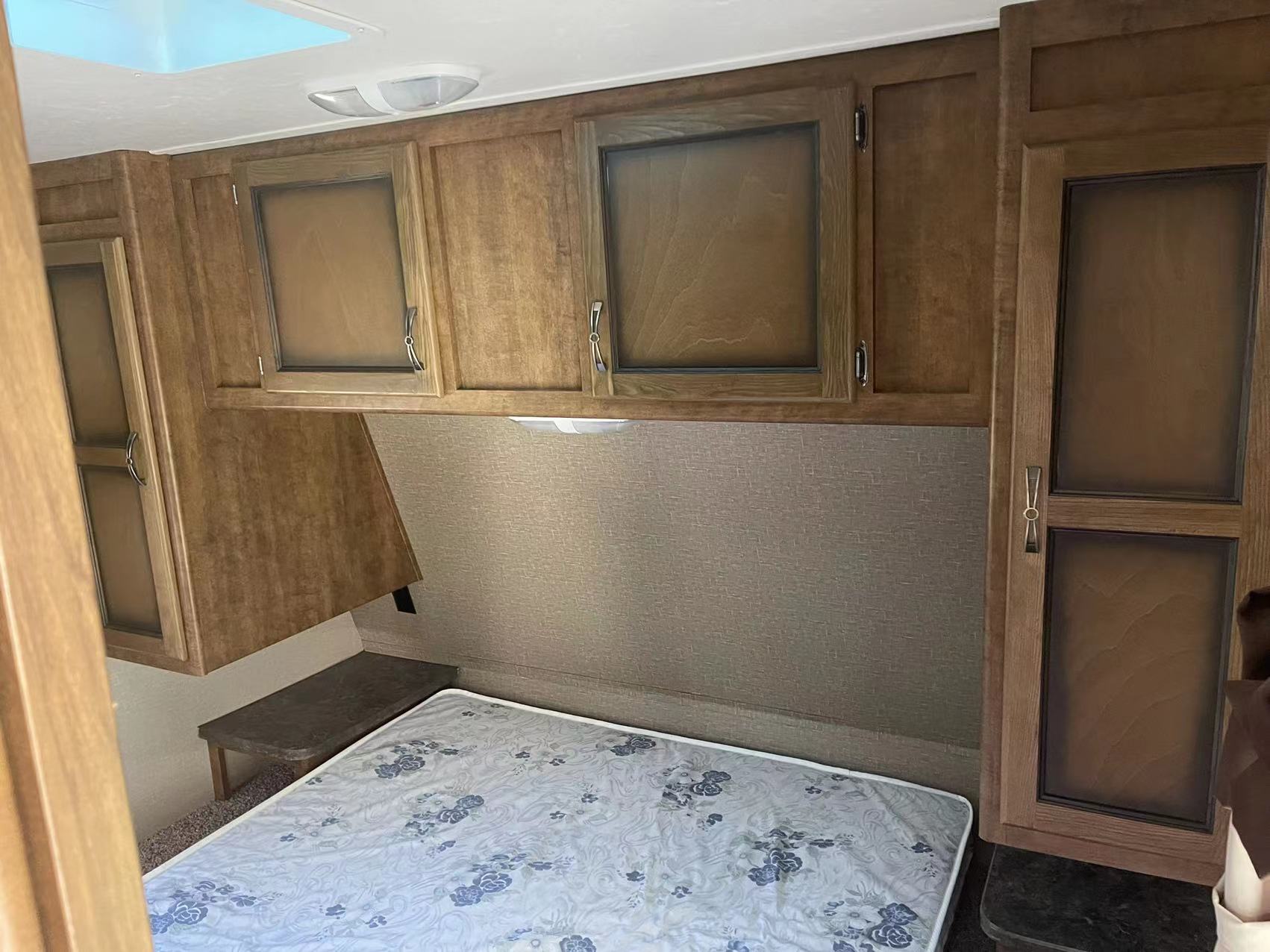 RV rental interior: cozy bedroom with overhead cabinets, a comfortable bed, and convenient storage for your travels.. Crossroads RV Rezerve 2016