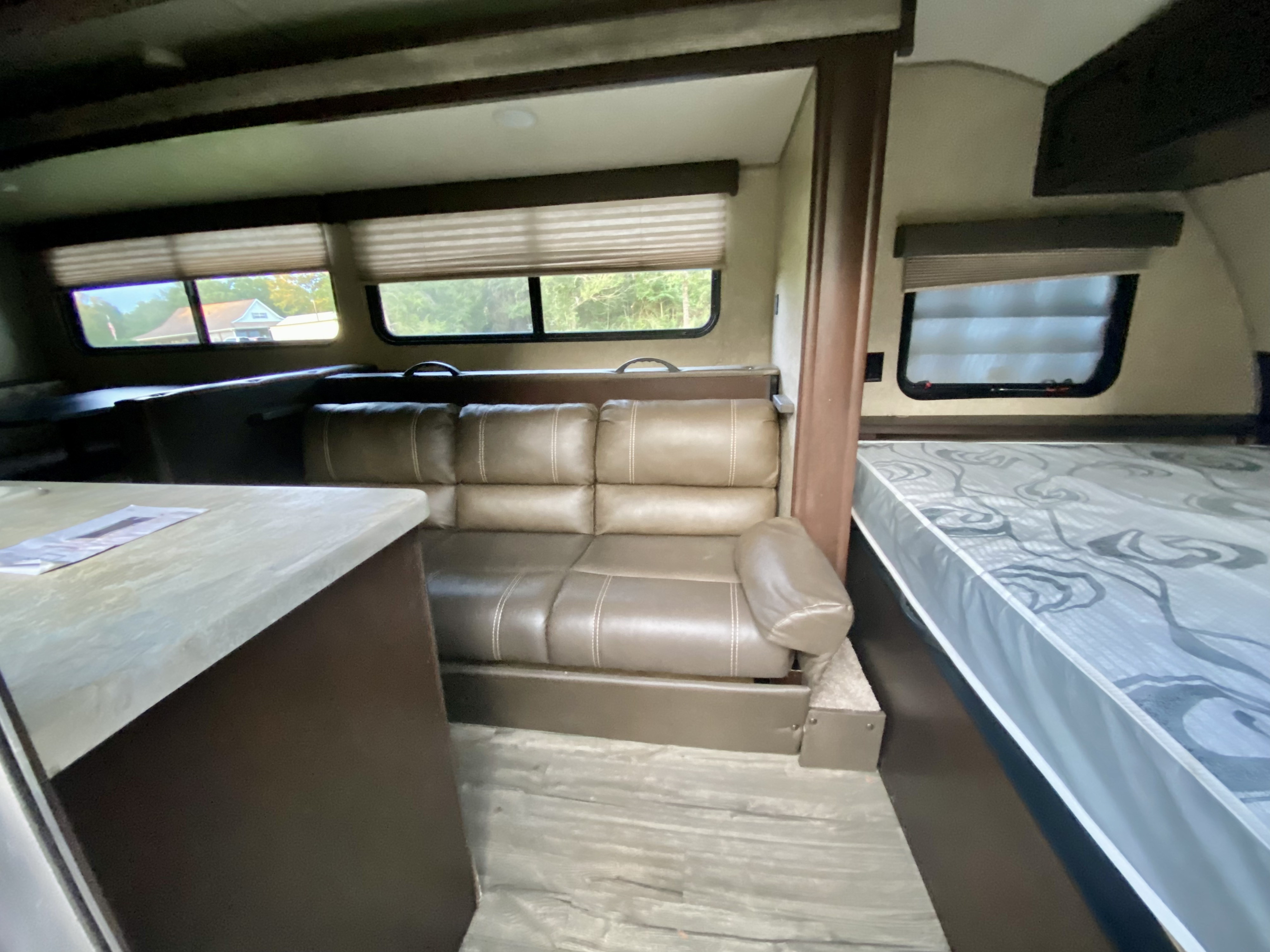 Cozy RV rental interior showing a plush sofa, dinette, and part of the bed, perfect for your next adventure.. Forest River Cherokee Wolf Pup 2018