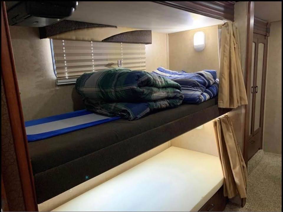 RV rental interior: cozy bunk beds with comfy mattresses, folded blankets, privacy curtains, and reading lights.. Jayco Greyhawk 2014