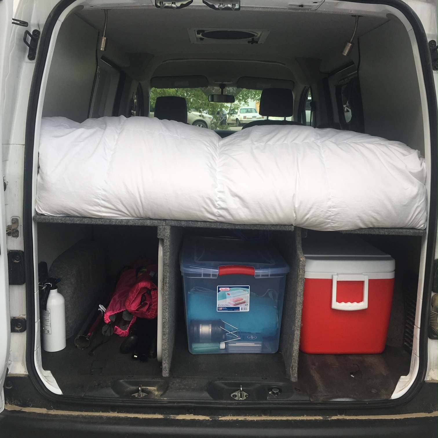 RV rental: Van interior showing organized bed platform, under-bed storage with cooler, and gear.. Nissan PRIMASTAR 2014