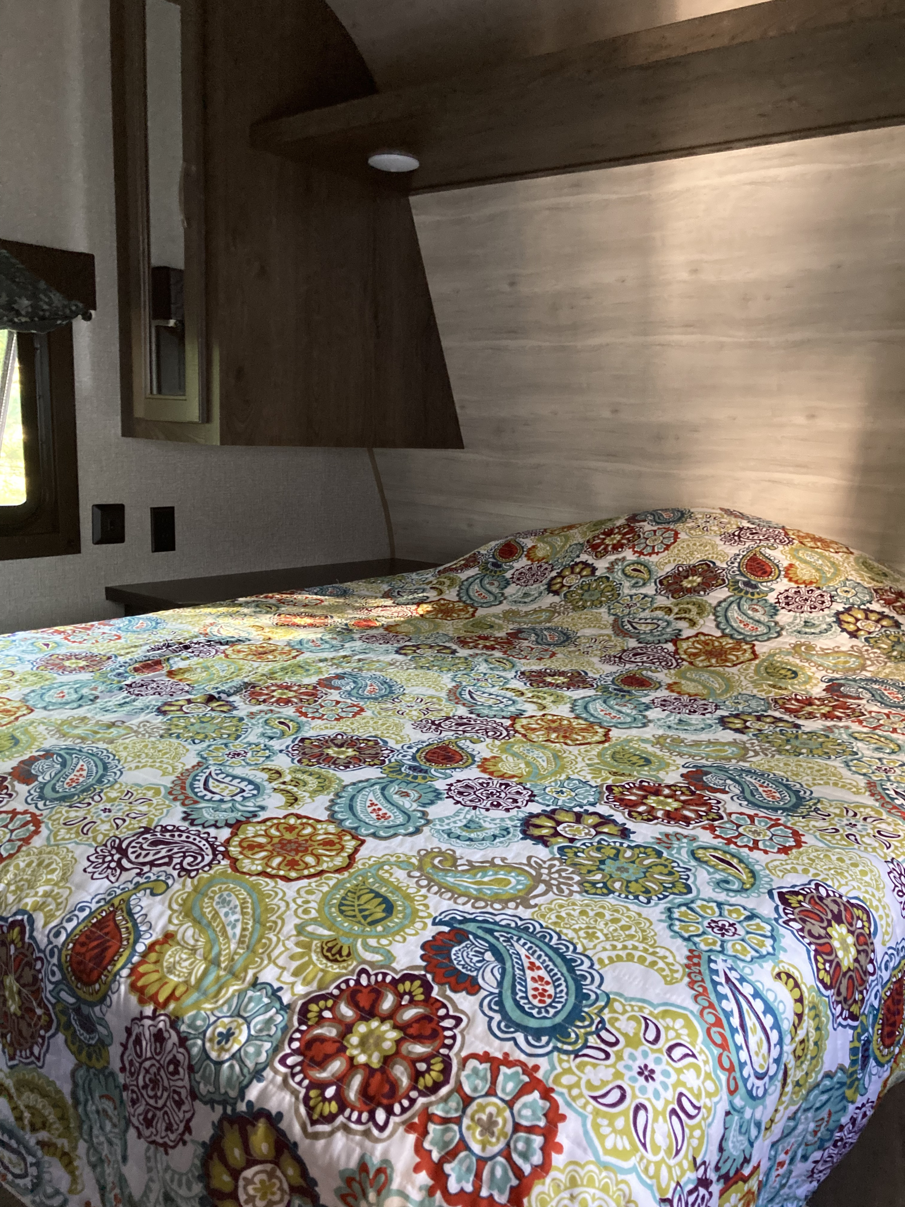 Colorful bed with paisley quilt in an RV rental bedroom, offering a comfy sleeping space.. Jayco Jay Flight SLX 2021
