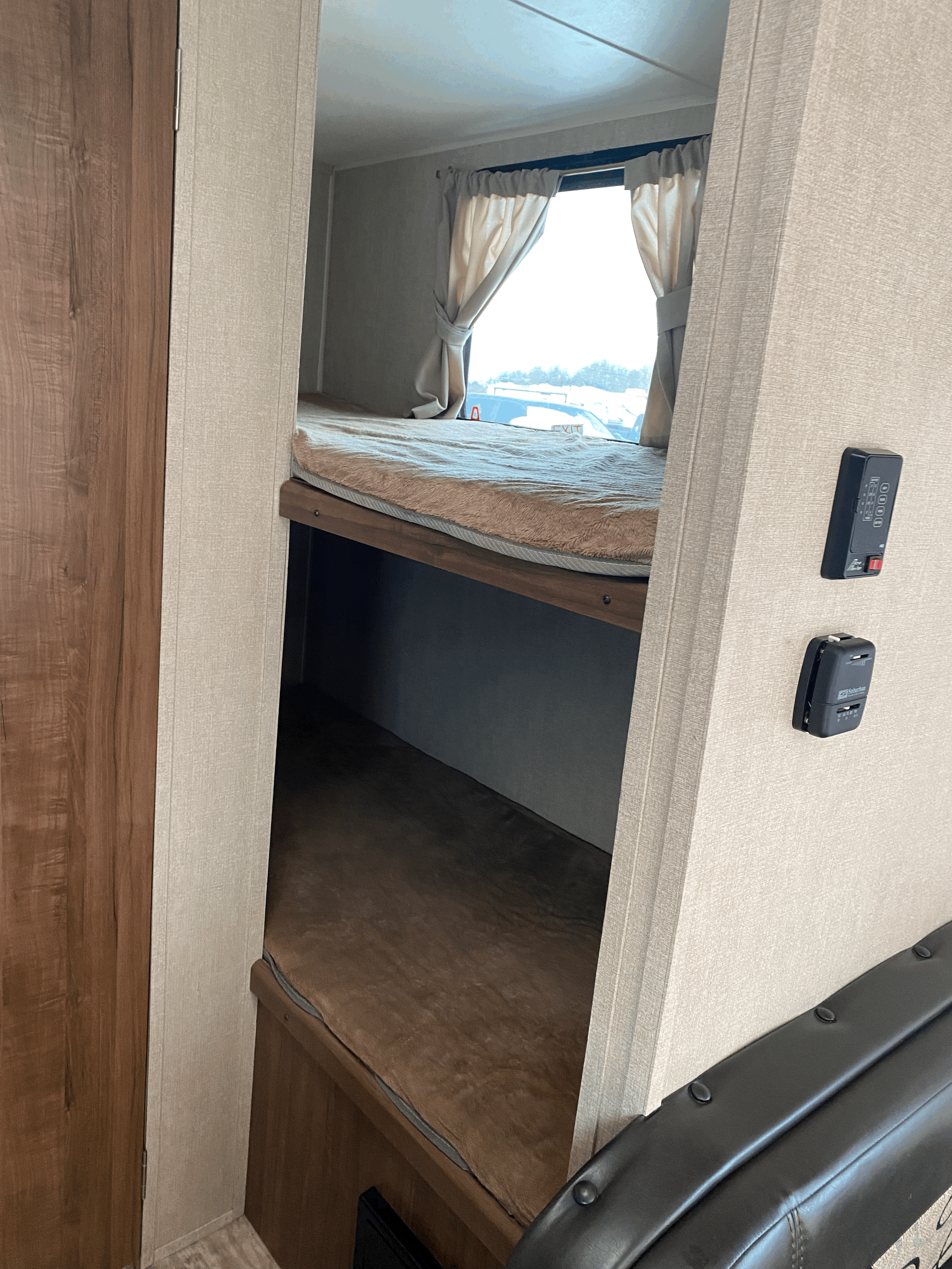 Cozy RV rental interior featuring comfortable bunk beds with a window, ideal for your next adventure.. Gulf Stream Kingsport Super Lite 2018