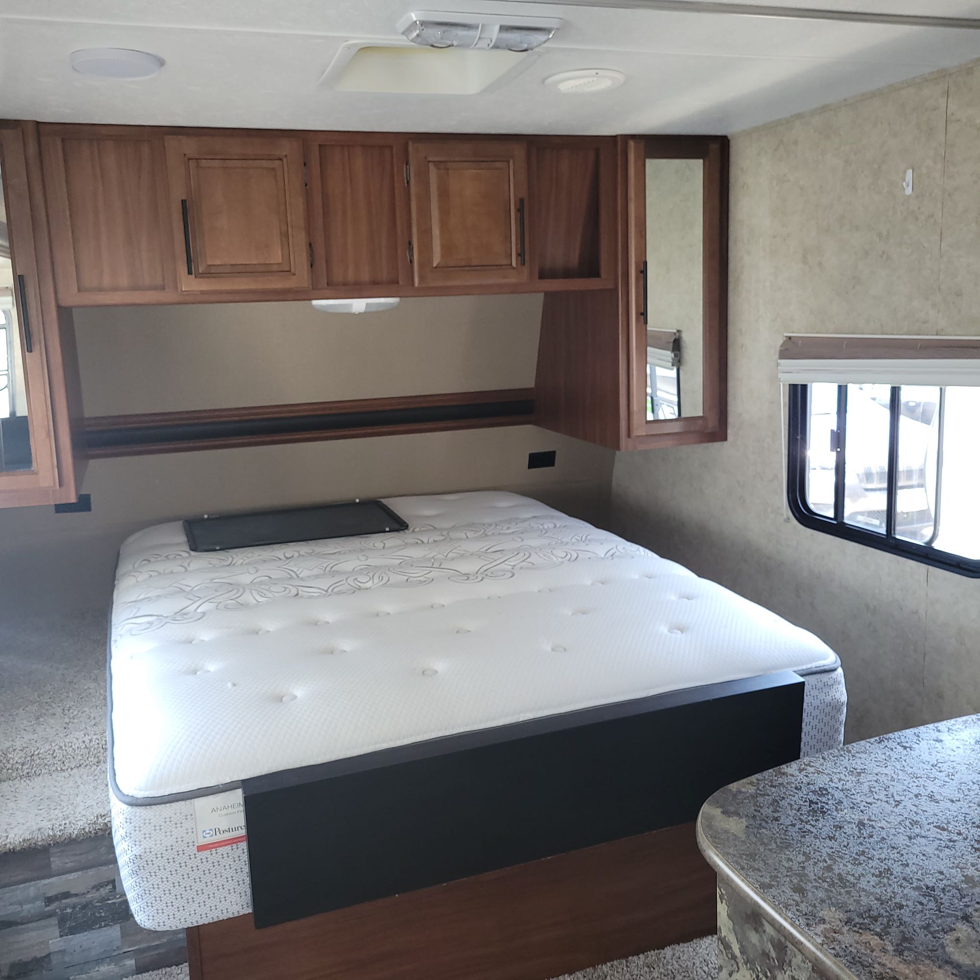 RV rental bedroom featuring a comfortable mattress, overhead storage, and window. Ideal for your next adventure.. Keystone Cougar 2014
