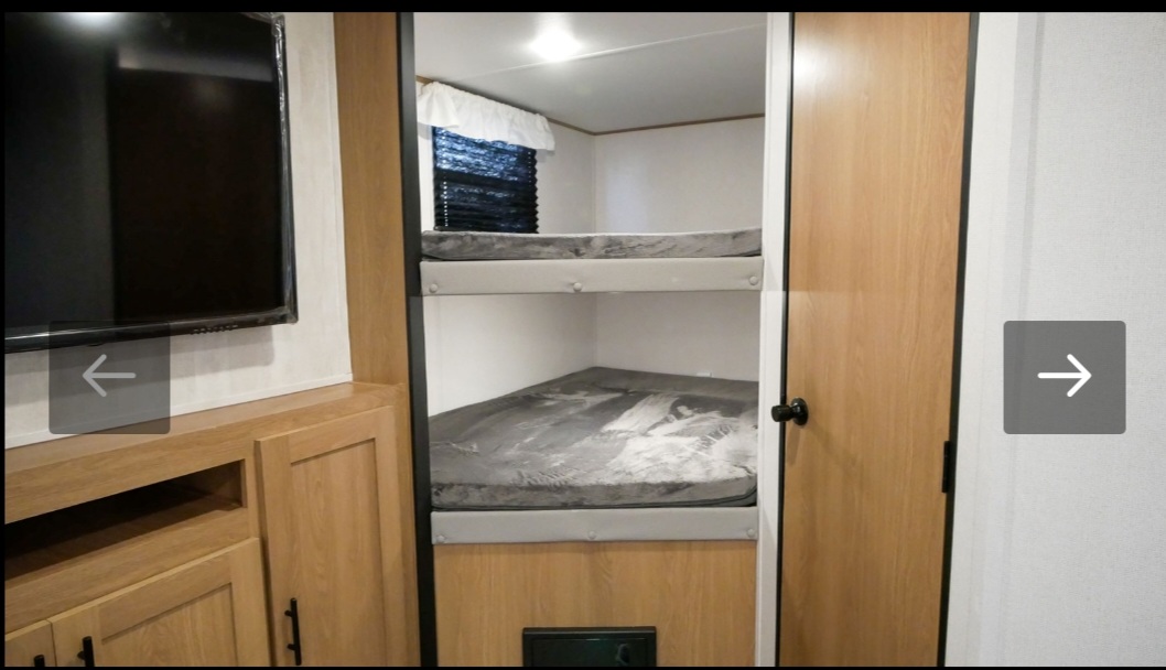 RV rental interior features: cozy bunk beds, a mounted TV, and storage. Ideal for family adventures on the road.. Avenger Avenger Trailer 2022
